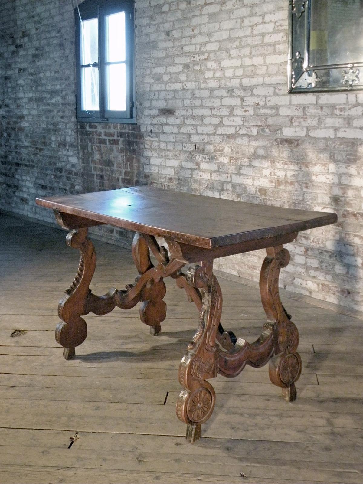 
Very unusual and rare 17th Century Spanish Walnut Table, (likely Aragonese), with a one-plank top, supported by two interestingly carved lyre legs,
each embellished with an animal-carving, joined by conforming, shaped stretchers.
The table is left