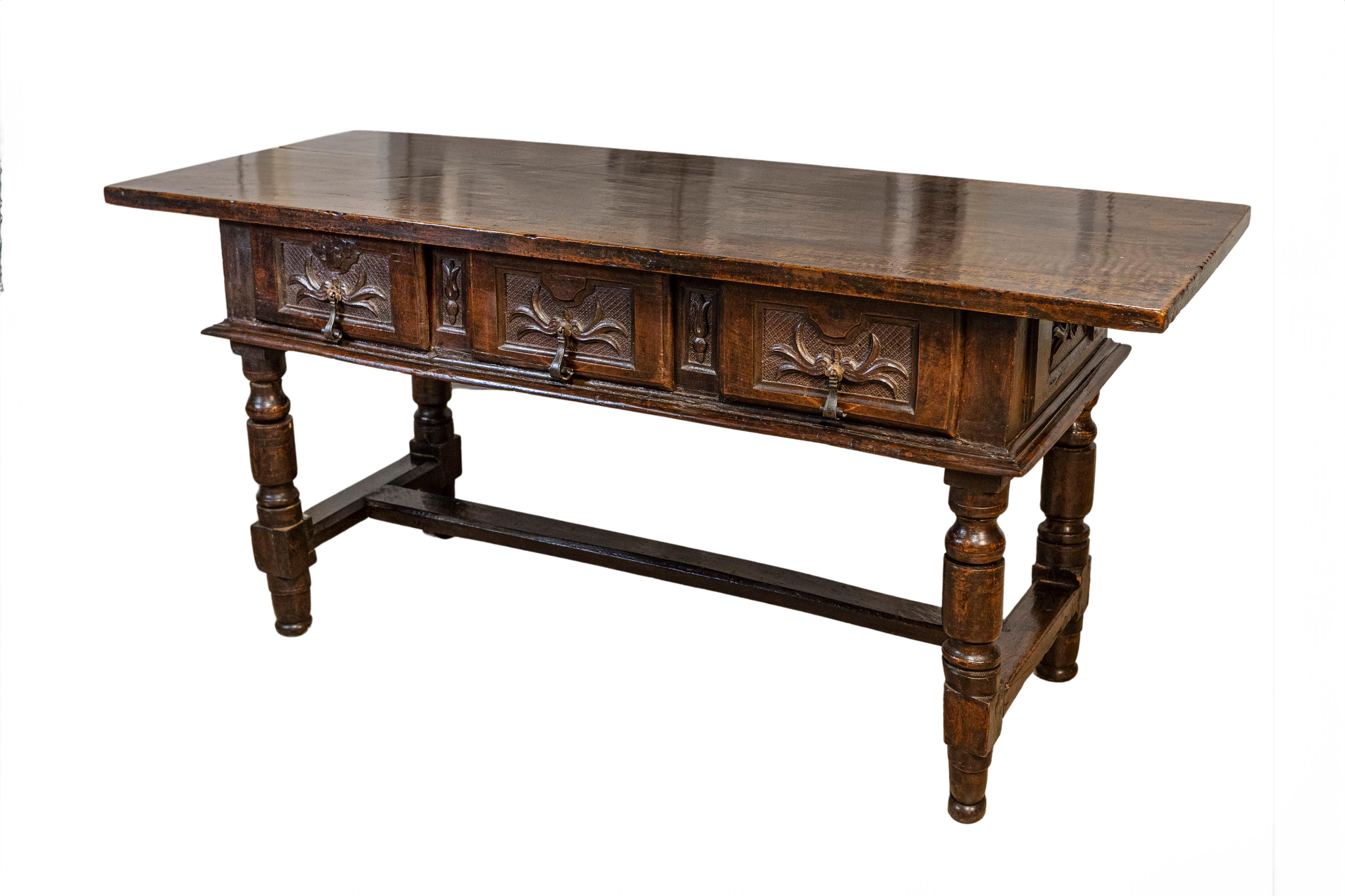 Spanischer Barocktisch aus Nussbaum aus dem 17. Jahrhundert mit drei Schubladen, geschnitztem Blattwerk auf Kreuzschraffuren, gedrechselten Beinen und H-förmiger Querstrebe. Dieser Tisch aus Nussbaumholz aus dem spanischen Barock des 17.