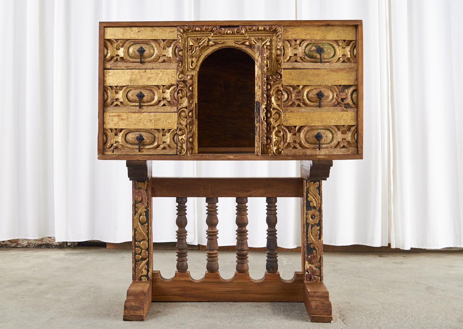 Rustic large Spanish baroque bargueno style cabinet or chest on stand crafted from thick pine. The beautiful case has exposed dove tail joinery and features 6 large storage drawers and is centered by an arched storage door with an ornate carved