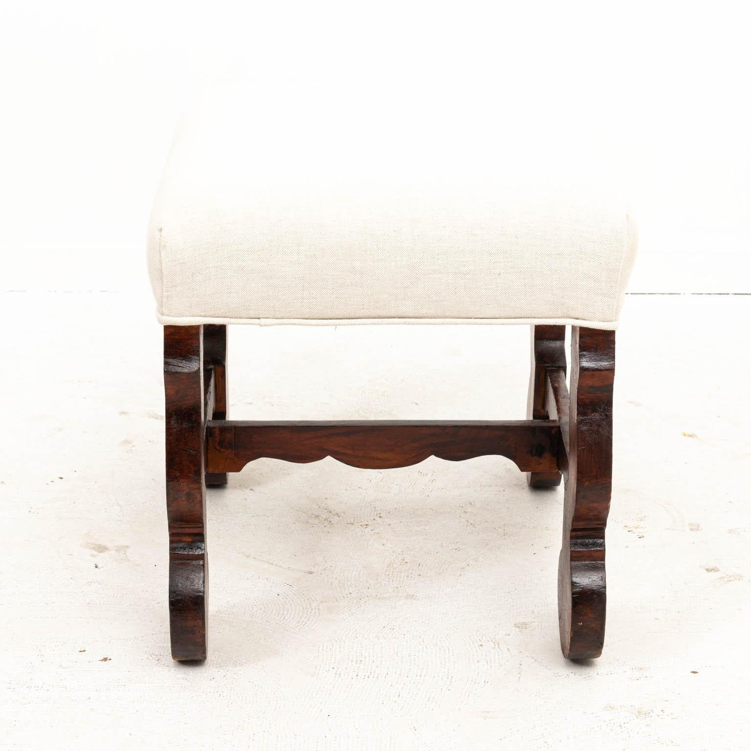 Spanish Baroque bench in walnut with upholstered seat. Made in Spain, circa 1890s. Please note of wear consistent with age including chips and finish loss.