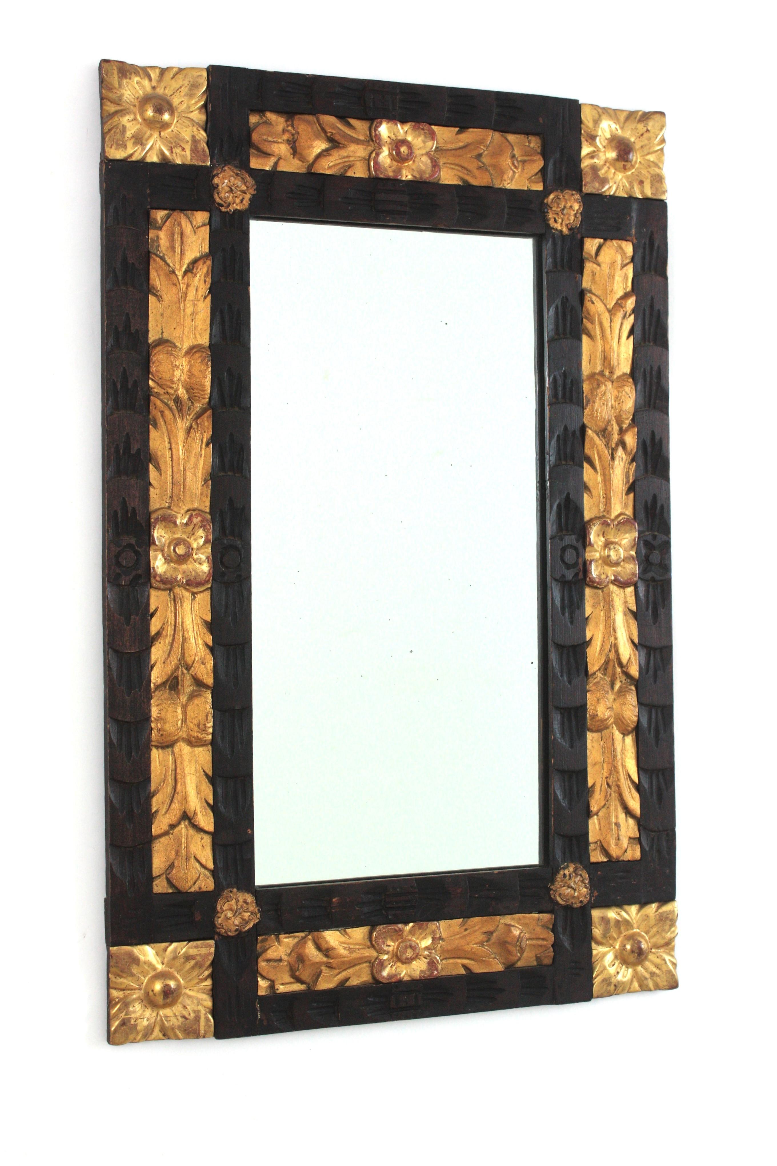 Spanish Revival Schwarz und Giltwood Rechteckiger geschnitzter Spiegel mit Blumen in der Ecke
Spanien, 1930-1940.
Wunderschöner rechteckiger Spiegel im spanischen Barockstil, paketvergoldet und schwarz bemalt.
Dieser handgeschnitzte Holzrahmen ist