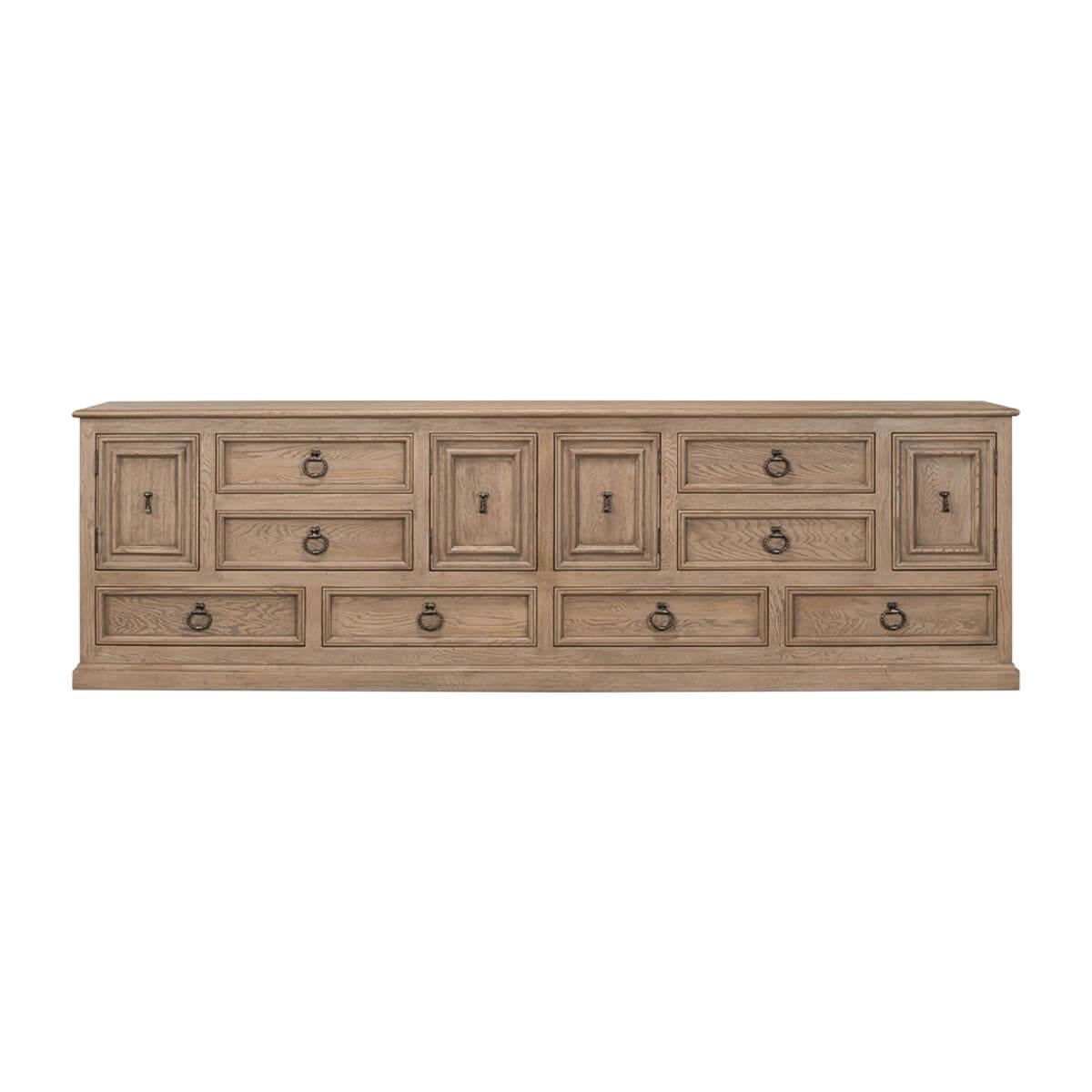 Expertly crafted with a keen eye for detail, this piece showcases the ornate aesthetic characteristic of the Baroque period, featuring bold geometric carvings and finished in the barn gray.

With multiple drawers and cupboards, the credenza has