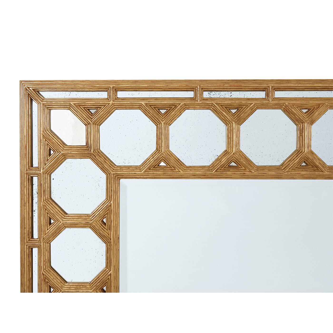 A Spanish Baroque style gilt mirror. This beveled-edge antiqued mirror center is set in a frame of consecutive octagonal coffered mirrored plates. The optics are gorgeous in this decorative mirror. May be hung horizontally or