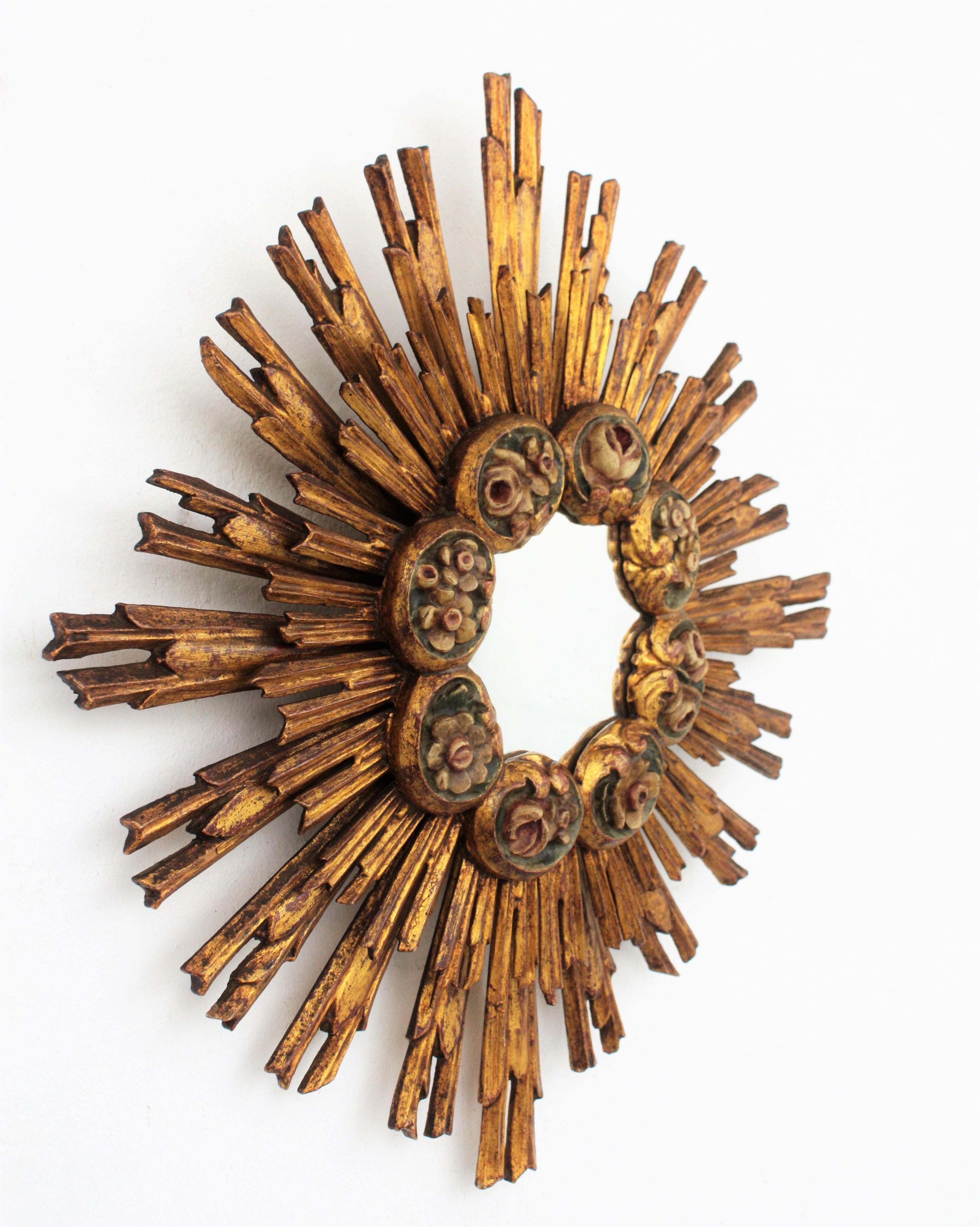 One of a Kind Hand Carved Double Layered Giltwood Sunburst Mirror with Carved Polychrome Floral Details. Spain, 1920s.
This wall mirror features s a layer of long rays at the back part and a layer of shorter ones with a patern of polychromed