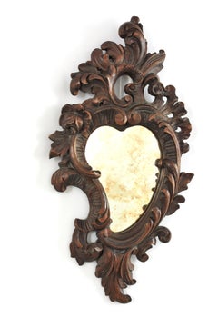 Espejo barroco español con forma de corazón, de madera de nogal y con marco decorado con motivos vegetales, tallado a mano
