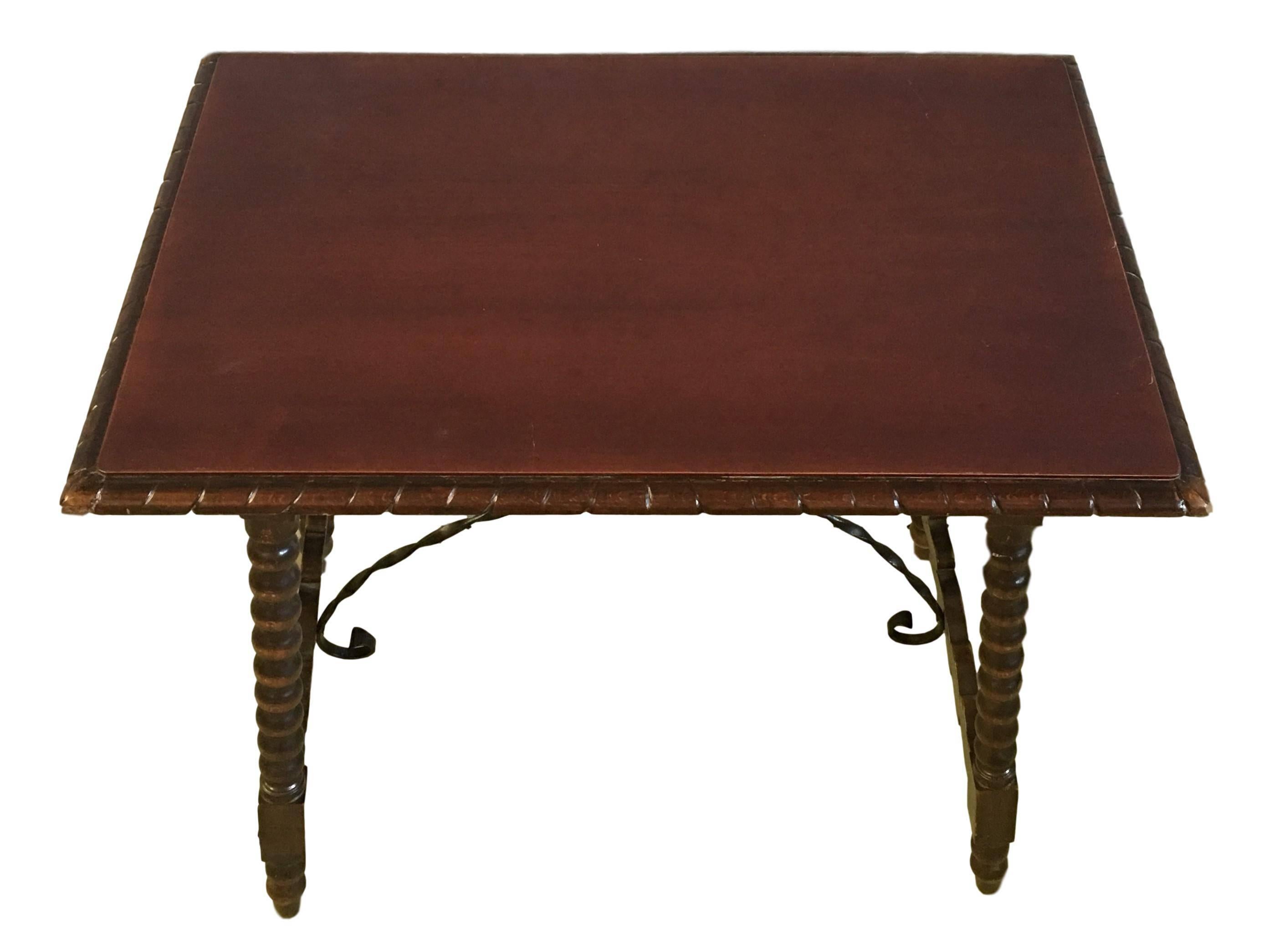 20th century Spanish Baroque ebonized side table with iron stretcher and carved top in walnut.