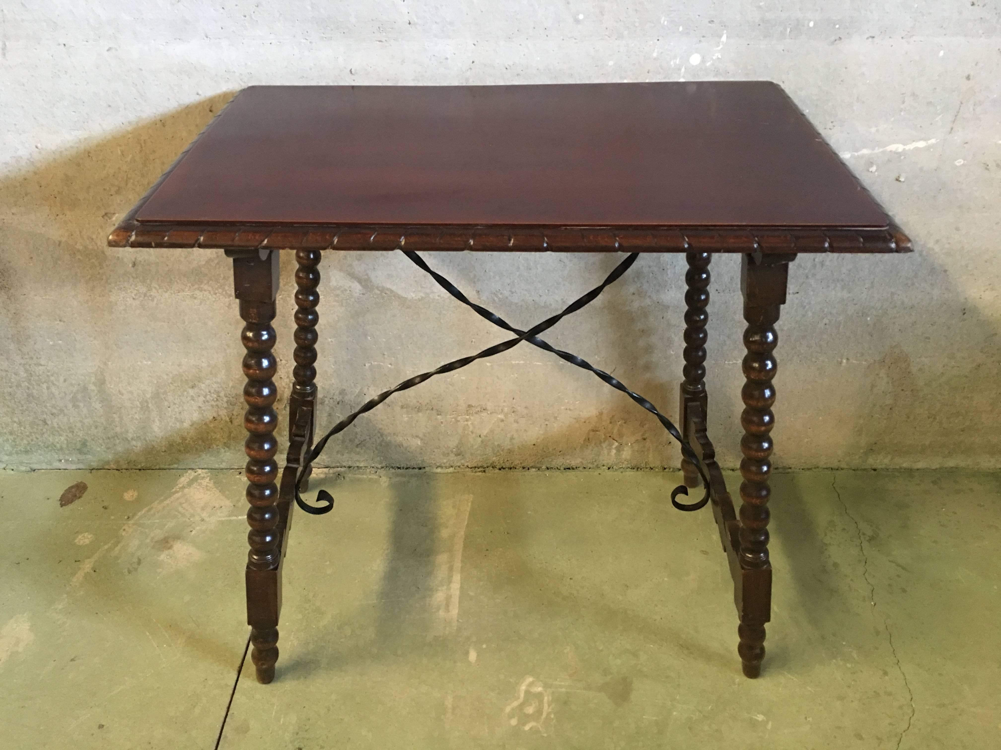 Early 20th Century Spanish Baroque Side Table with Iron Stretcher and Carved Top in Walnut