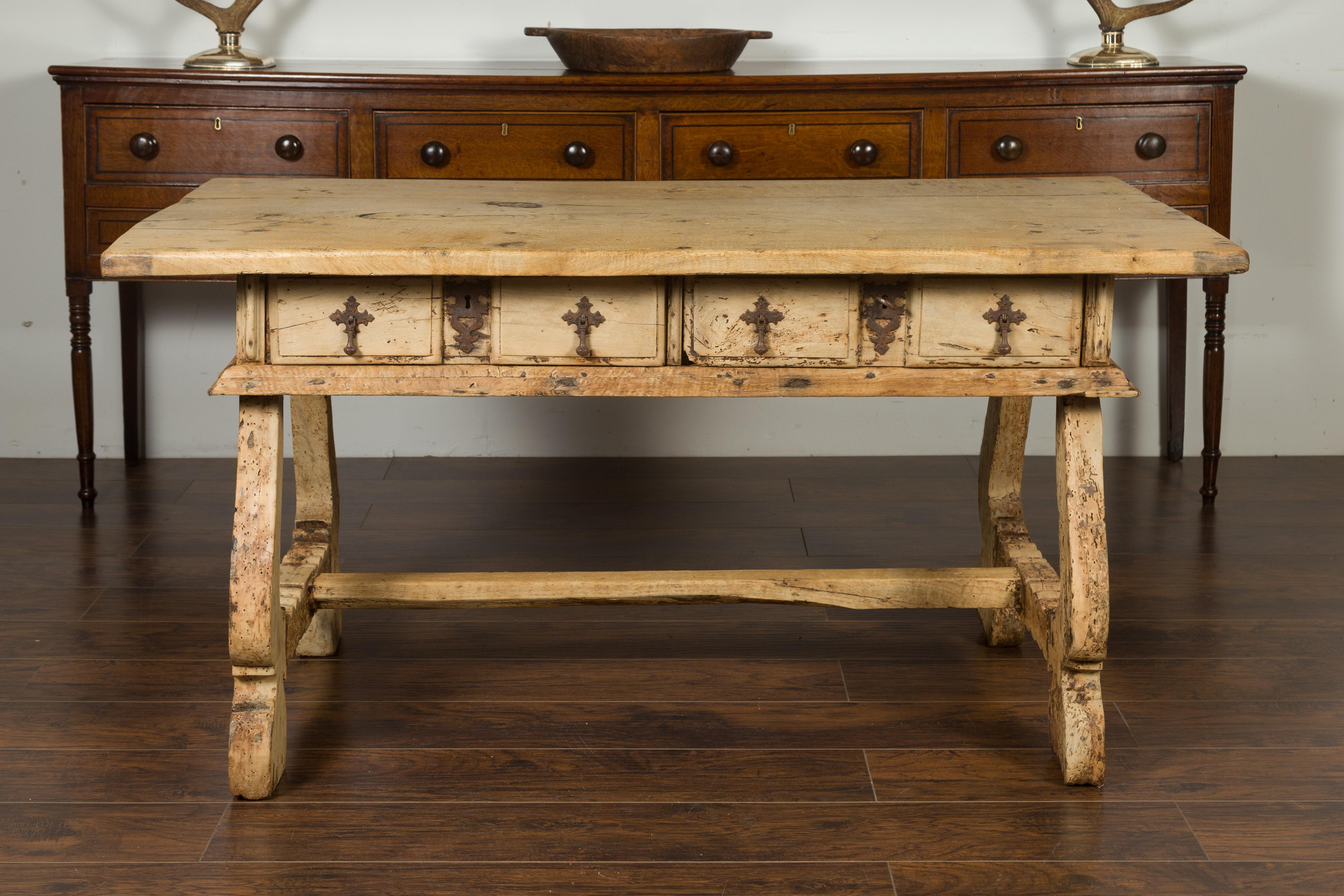 A Spanish Baroque style freshly bleached walnut trestle base farm table from the early 19th century, with two drawers and distressed patina. Created in Spain during the first quarter of the 19th century, this farm table features a rectangular