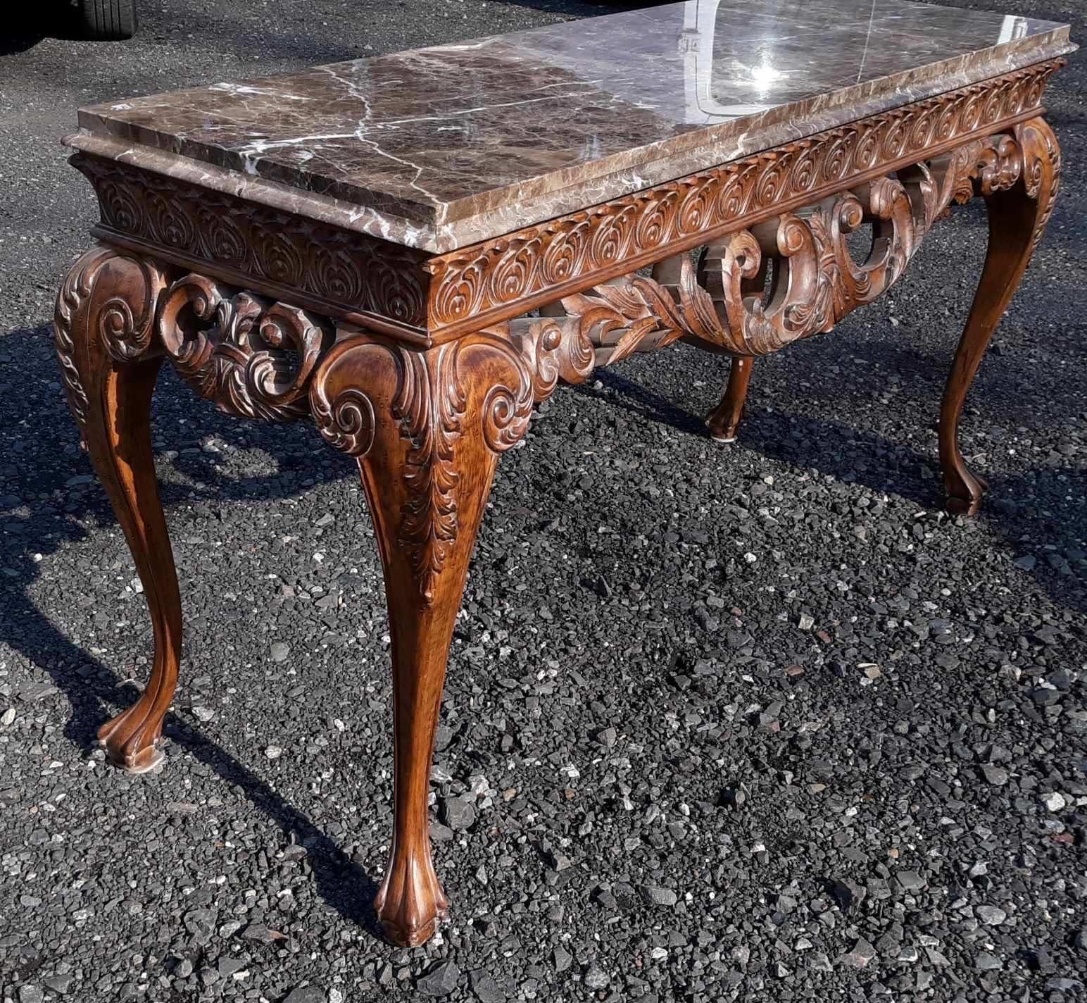 Elegant hand carved walnut and marble console table.  The elaborately carved base with reticulated apron supported buy four graceful carved cabriole legs.  The top is a thick bronze white and earth tone mpolished marble. 