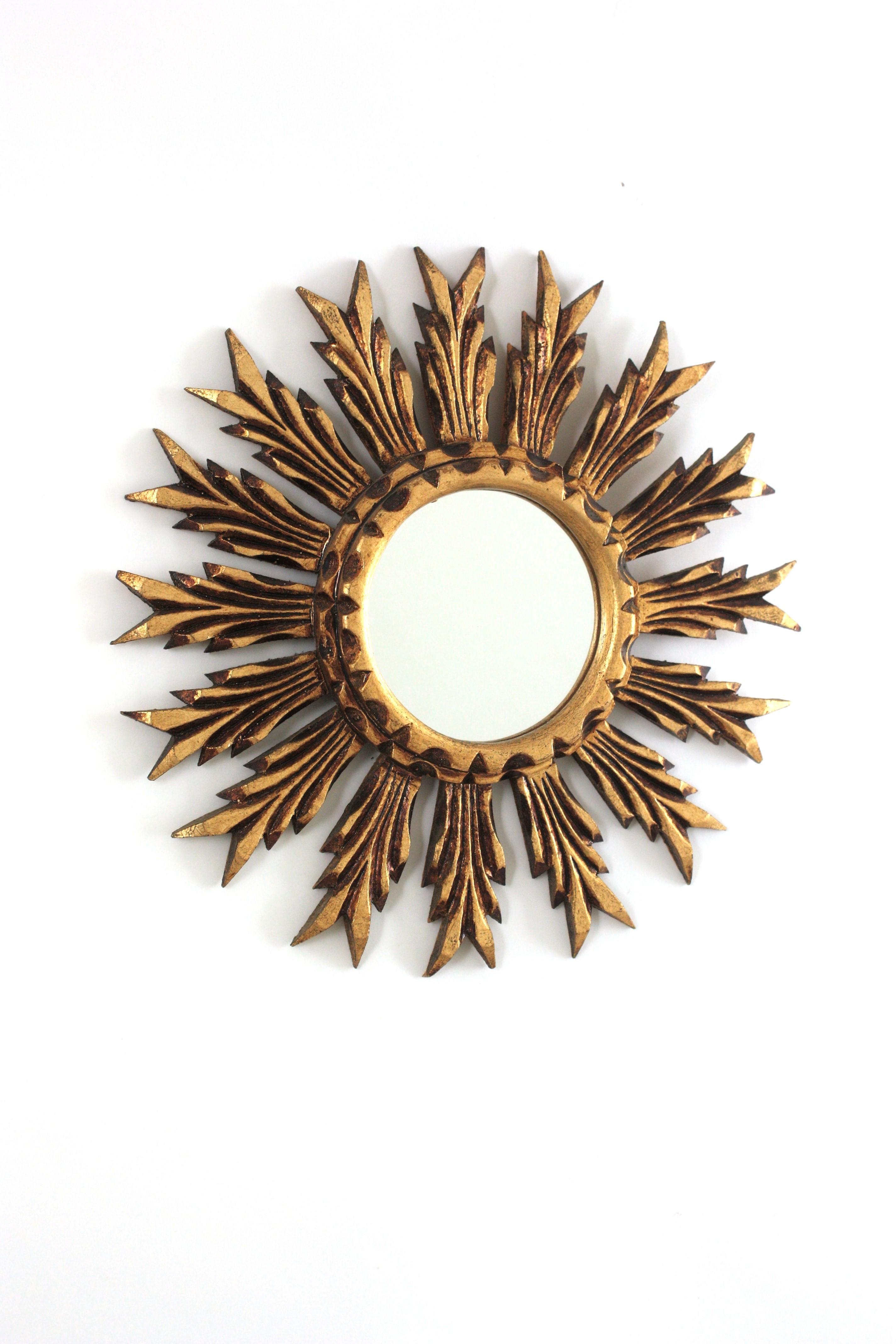 Miroir en bois doré de style baroque espagnol, années 1940
Superbe miroir de style baroque en bois sculpté et doré avec finition à la feuille d'or. 
Ce magnifique miroir en forme d'étoile ou de soleil a un cadre composé de rayons sculptés et un