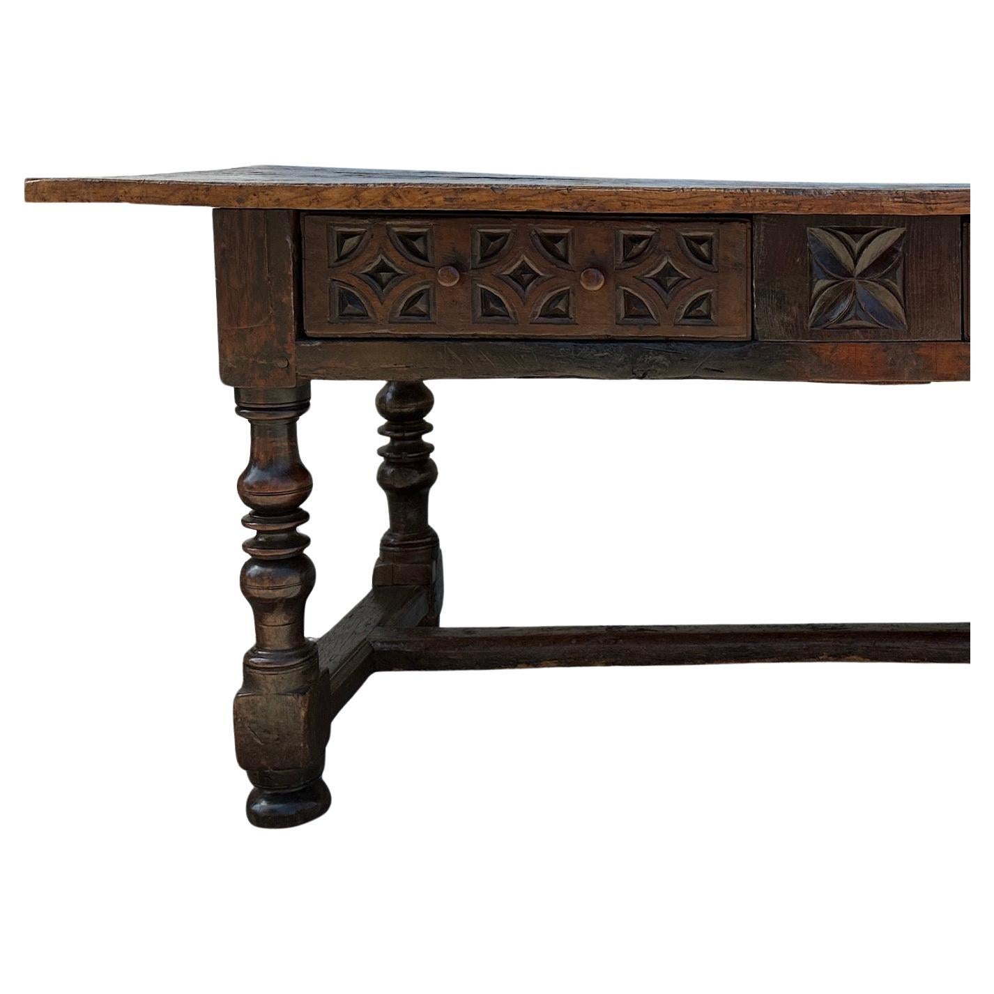 Spanish baroque style, hand carved, walnut library table.  Table features a two-plank top over a carved frieze with two drawers.  Turned legs connect a H stretcher.  