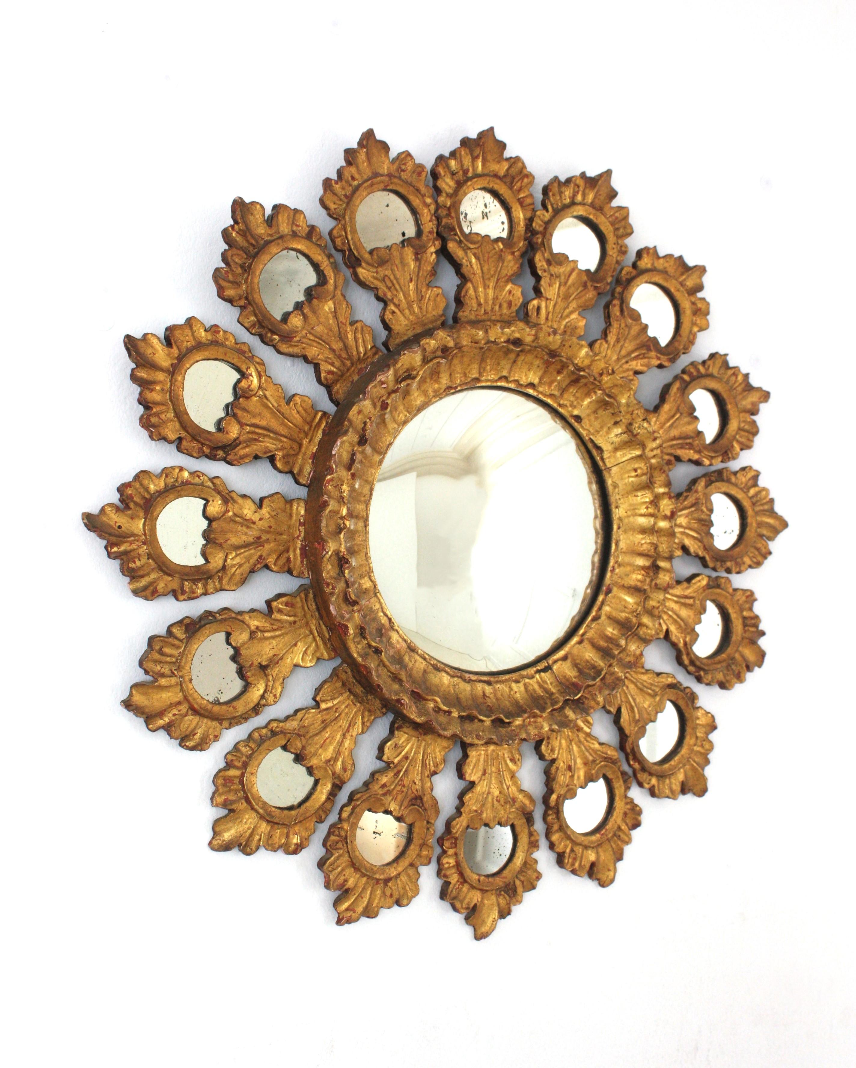 Gold Leaf Giltwood Sunburst Convex Mirror with Mirror Inlays, Spain, 1930s-1940s.
One of a Kind Hand Carved Giltwood Sunburst Mirror with convex glass.
Rare find.
This wall mirror features a heavily carved giltwood frame made of a layer of foliage