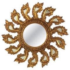 Espejo barroco español con diseño de rayos de sol, de madera dorada y marco tallado con motivos vegetales, 1940