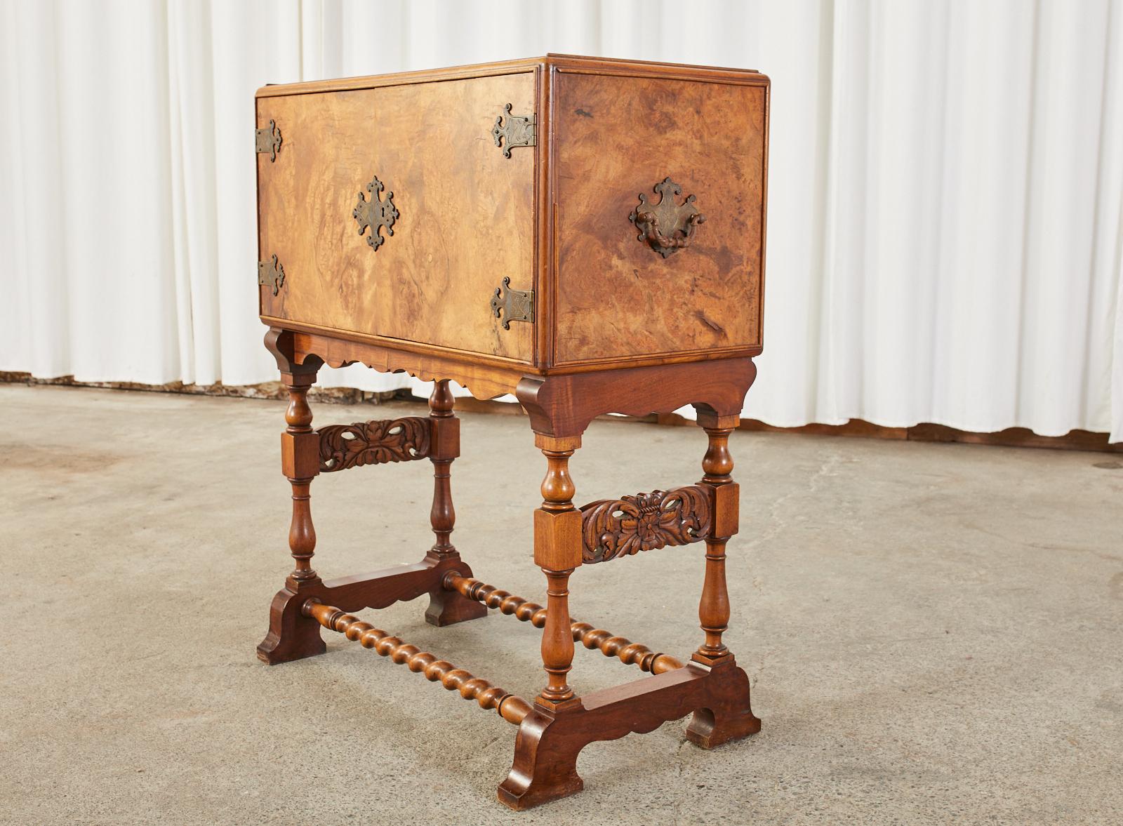 Petite Spanish cabinet or chest on stand made in the baroque taste in the manner of a vargueno cabinet. The cabinet features a burl walnut veneer case with decorative etched brass hardware and lock plates. Fronted by two locking doors with a key.