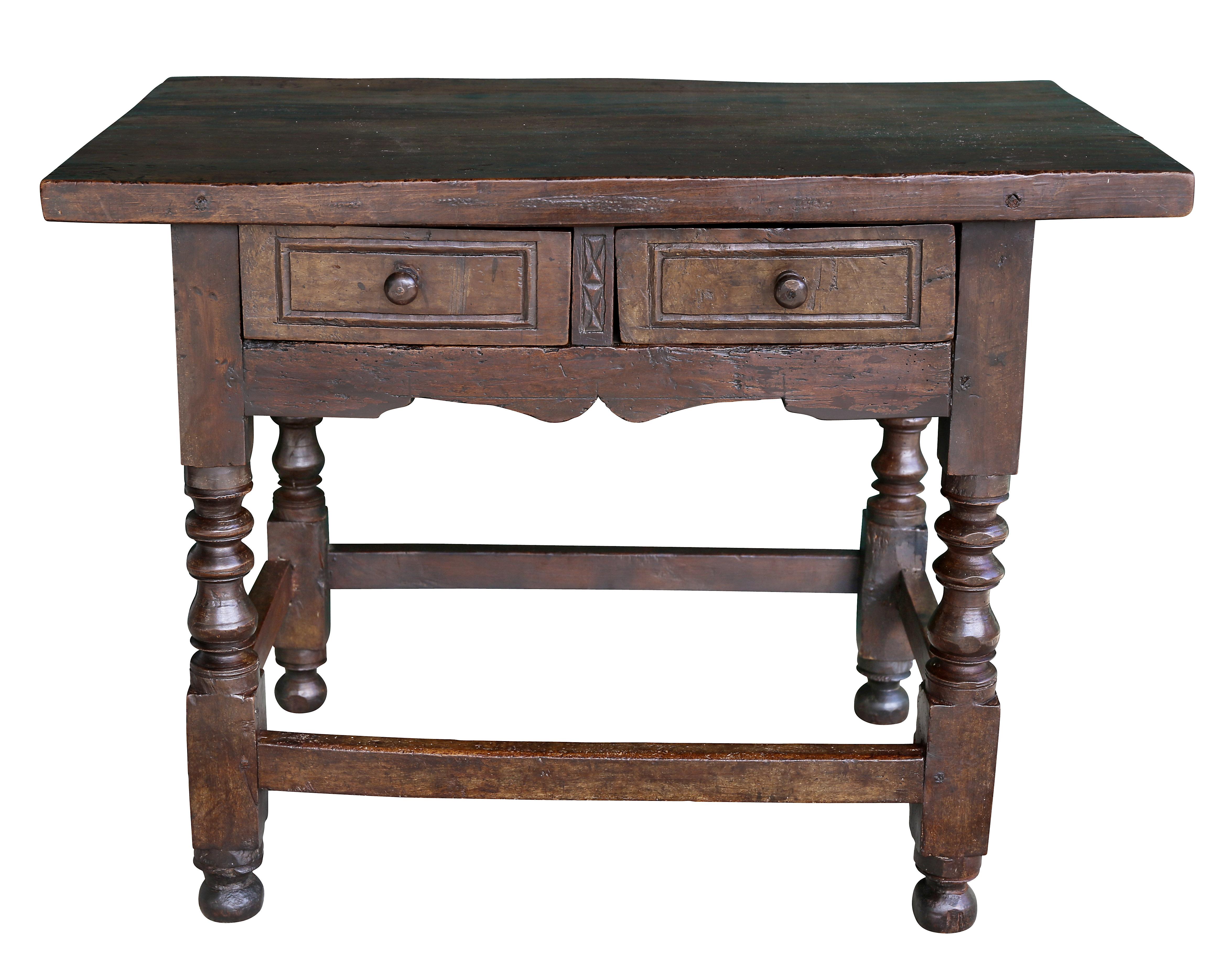 Rectangular top over two drawers with geometric carved drawer divider, raised on turned legs with a box stretcher.