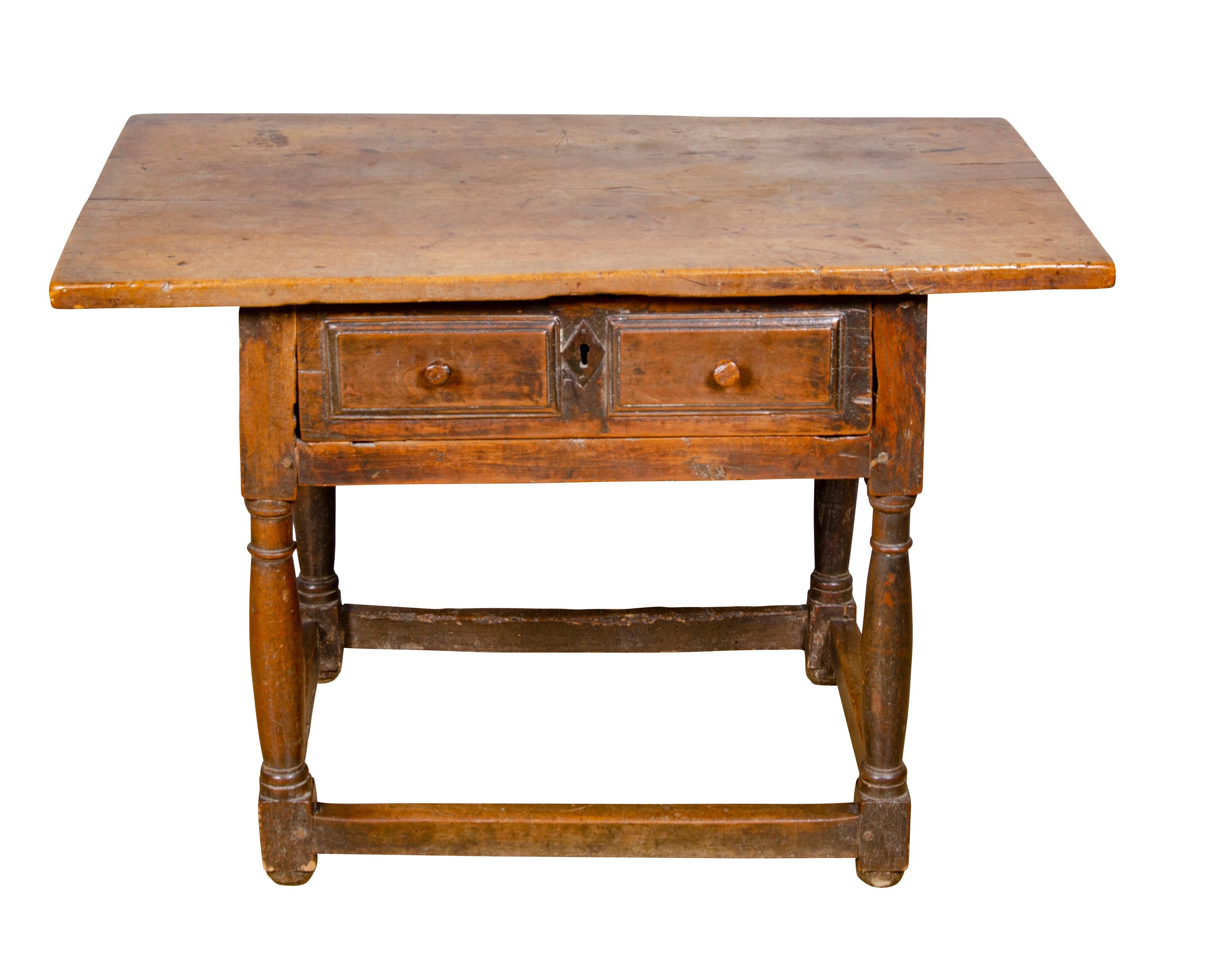Rectangular top over a drawer with wrought iron handle, raised on turned legs with box stretchers.