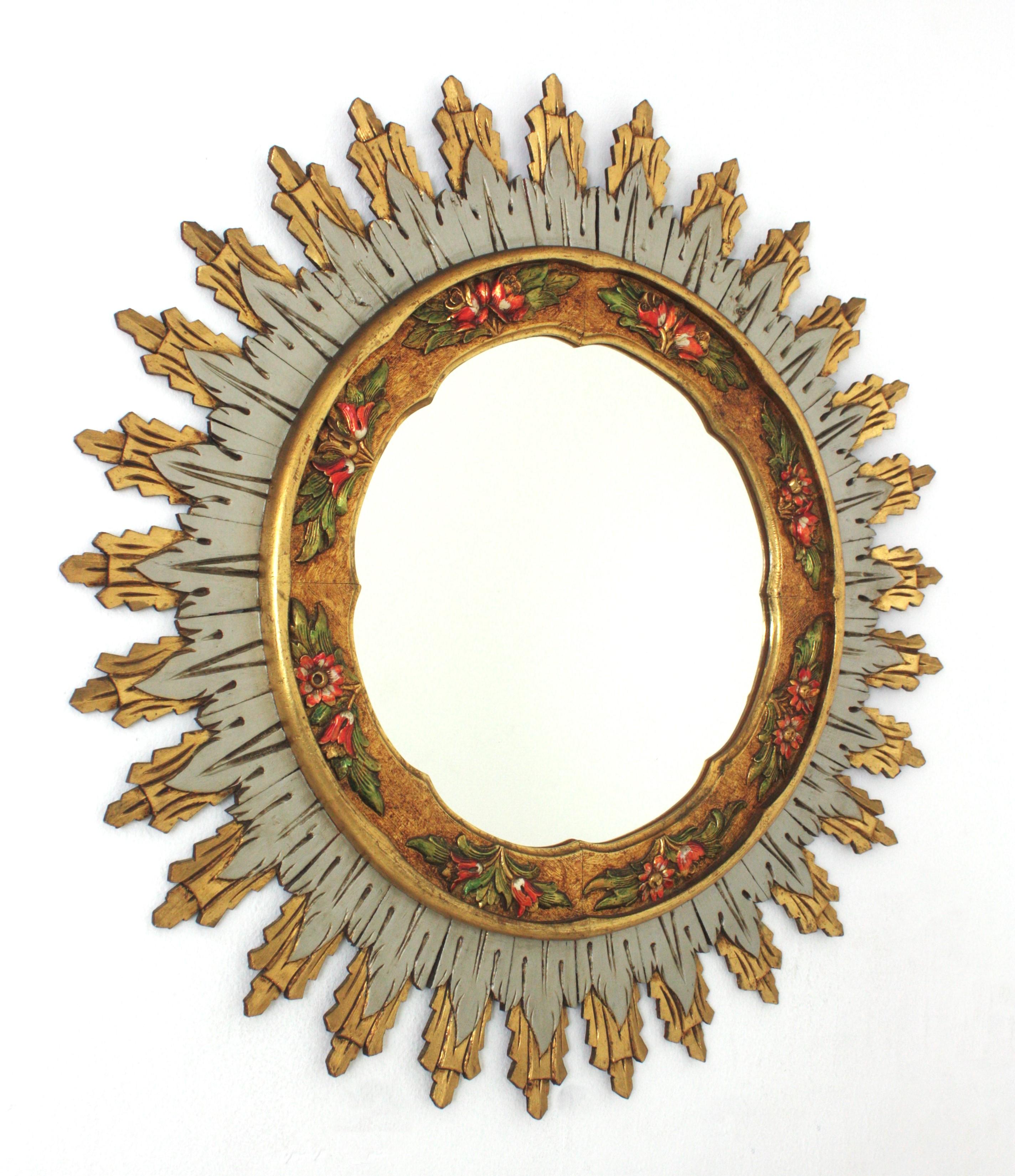 Giltwood Spanish Polychromed Barbola Sunburst Mirror
Double Layered Giltwood Sunburst Mirror with Carved Polychrome Floral Details. Spain, 1960s.
This wall mirror features features a layer of long rays at the back part and a layer of silver