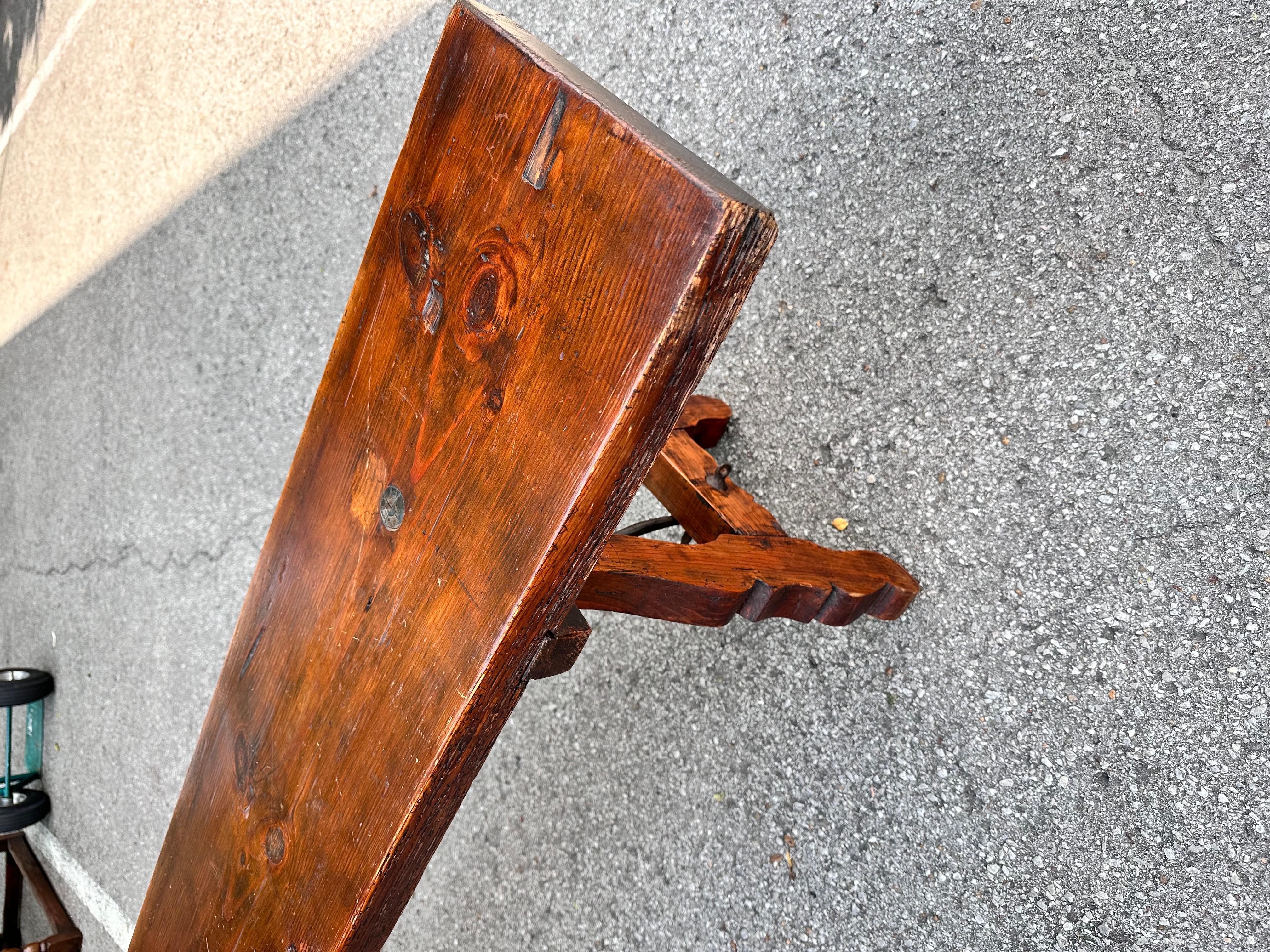 This is a stunning antique bench! This piece dates to 19th century Spain, and the patina and character on this piece are stunning! Beautiful tone and the antique iron brace underneath adds a gorgeous accent to the rich color of the wood. This would