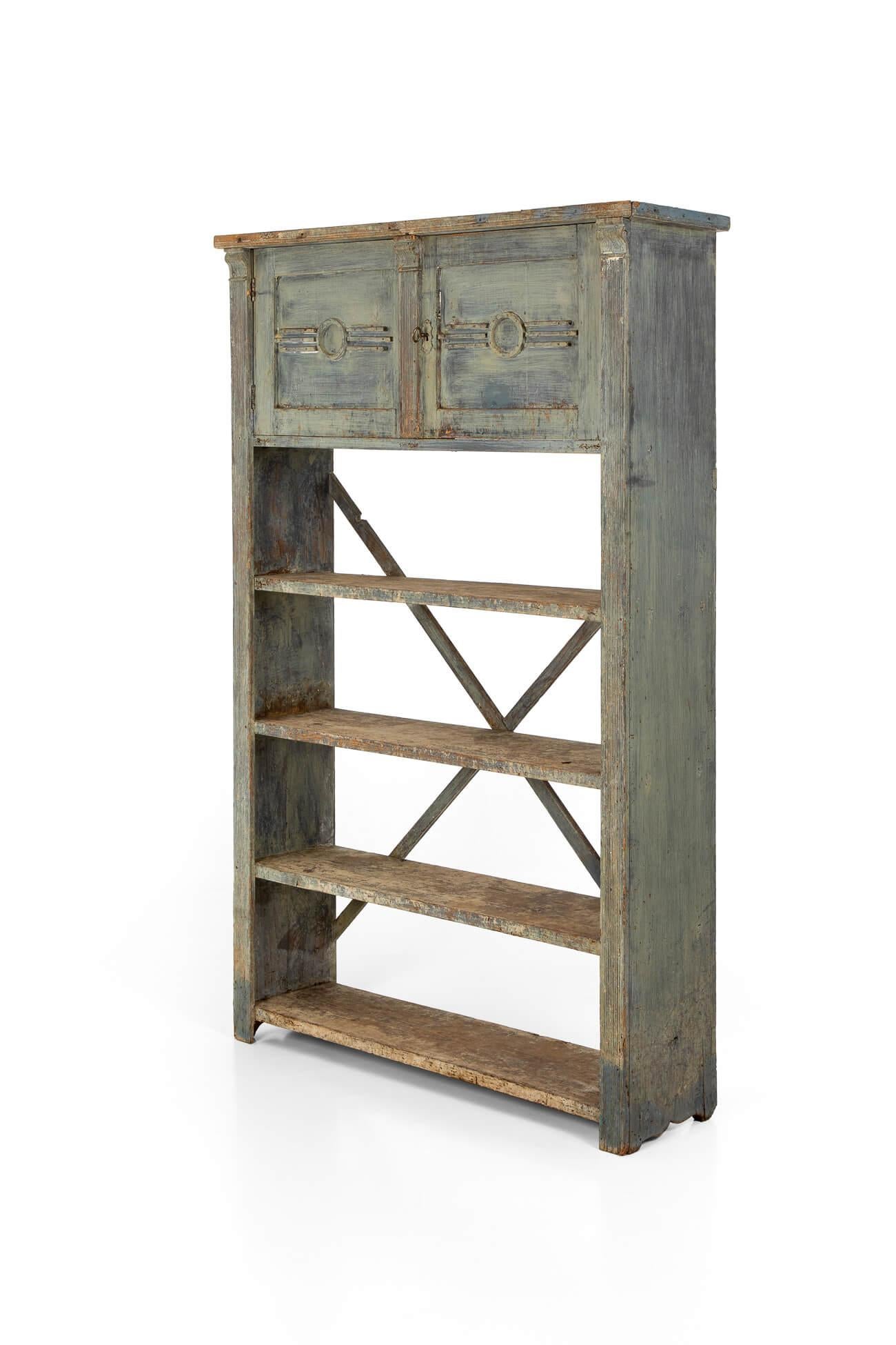 A delightful rustic Spanish bookcase in pine, with four wide shelves and two spacious cupboards to the top.

The shelves are united to the rear by a pair of x-shaped stretchers, with abstract moldings complementing both cupboard doors.

In its