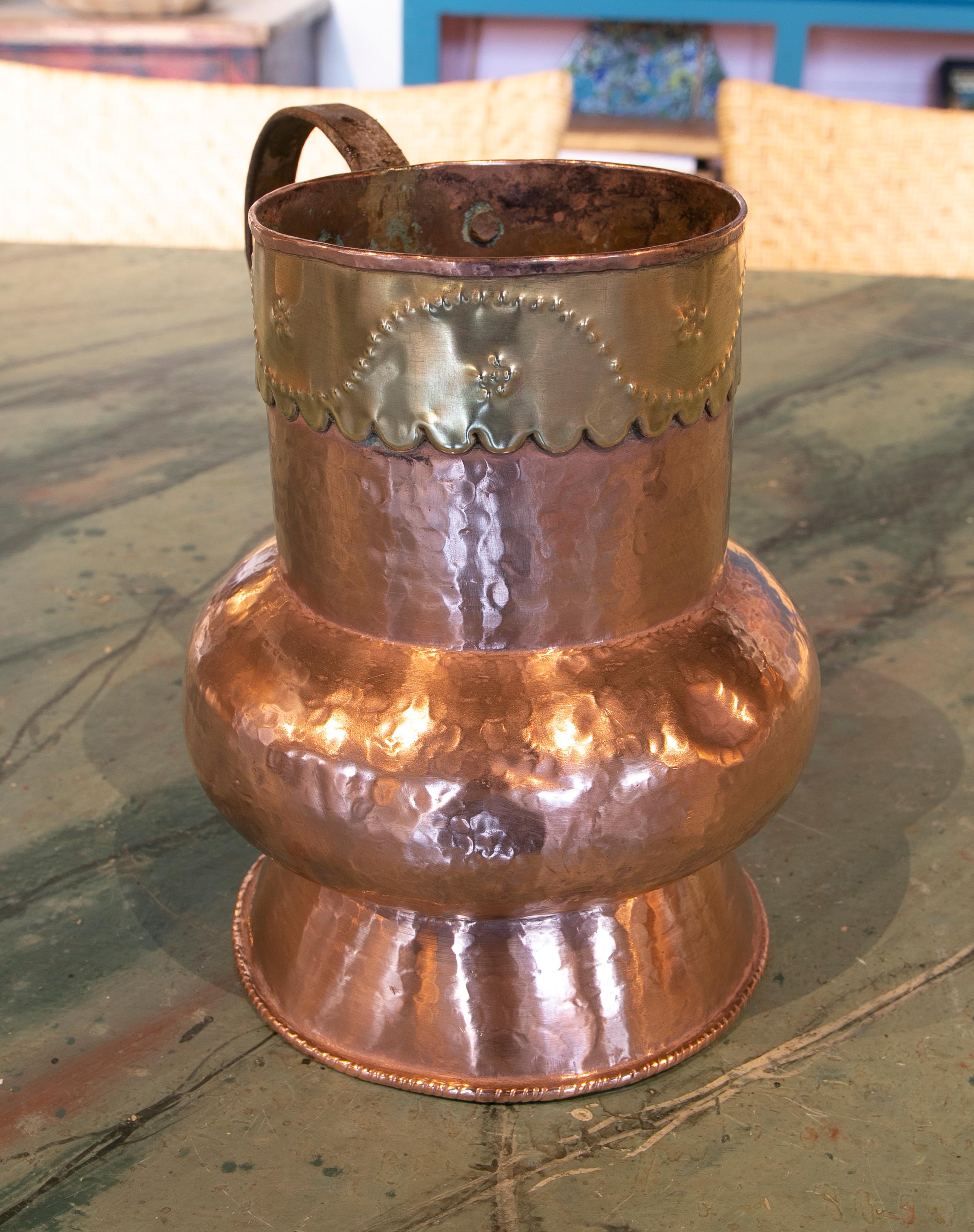 Spanish brass jug decorated with embossed skirt on the top.