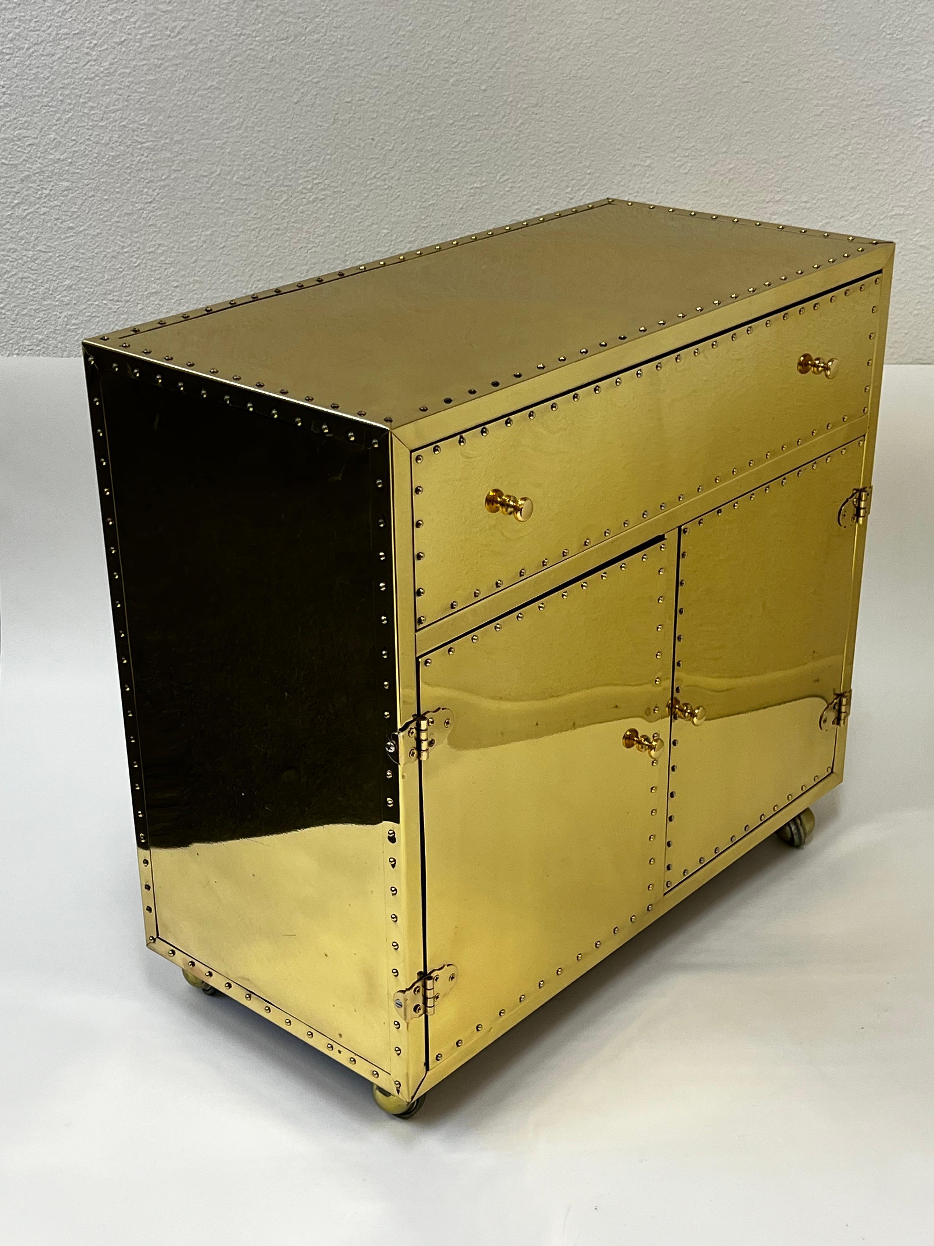 1970’s Spanish  polish brass nightstand or cabinet by Sarreid Ltd. 
Constructed of wood covered with polished brass sheets. 
In original condition shows some wear consistent with age( see detail photos).

Measurements: 26.5” Wide, 13” Deep, 24.75”