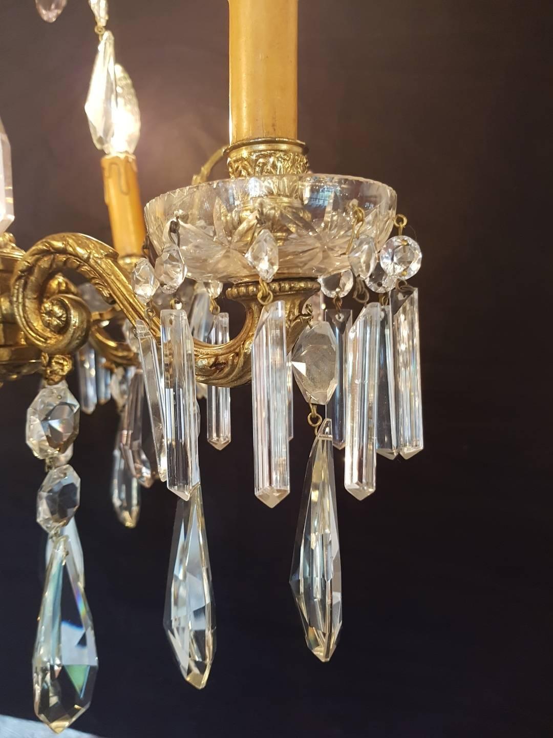 Spanish chandelier made of bronze and decorated with clear crystals. A few crystals are in pink color. The chandelier has four candle lights with bobeches. The crystal glass bowls in the centre are beautiful shaped. Great quality.

This is just