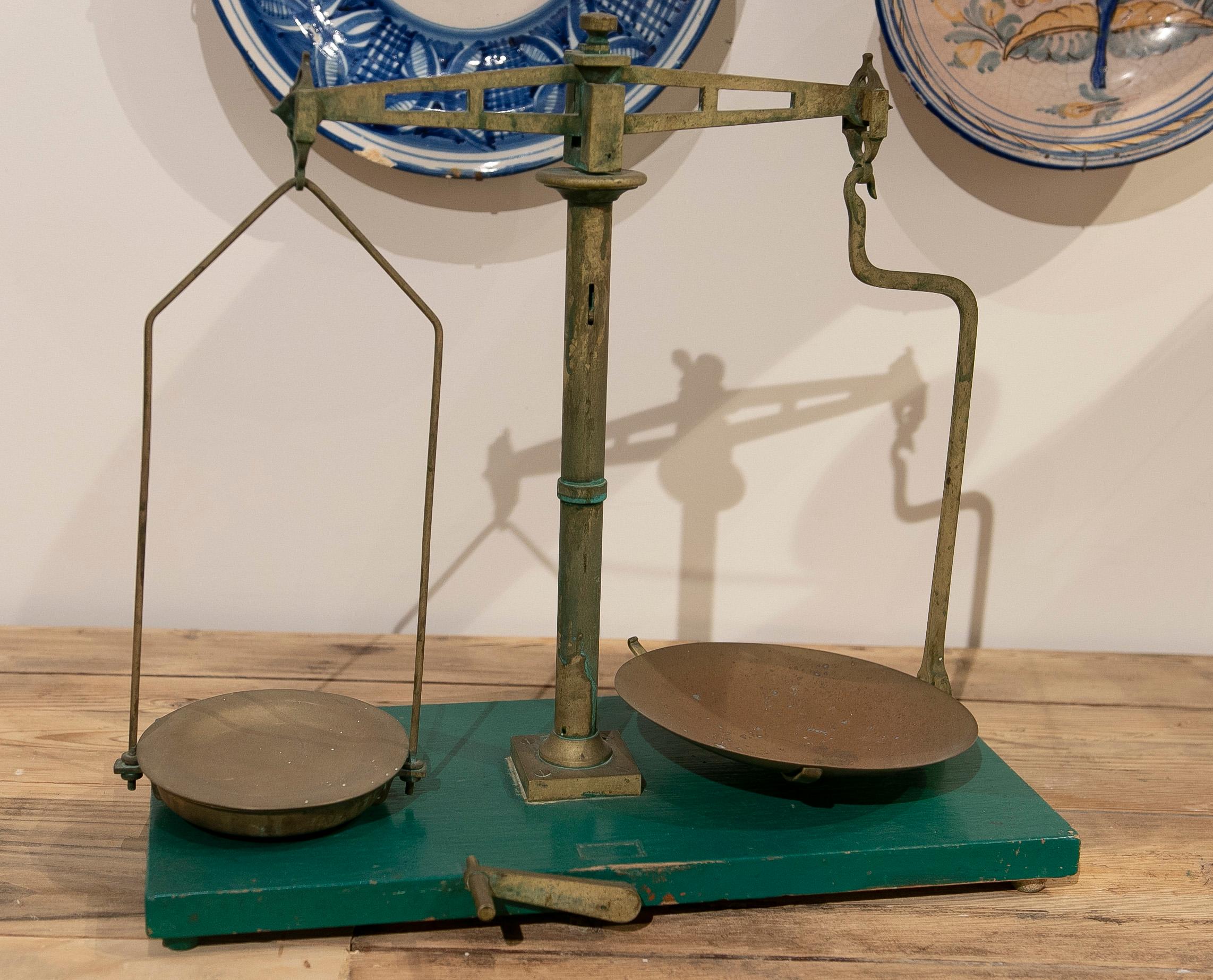 Spanish bronze balance scale with green painted wooden stand.