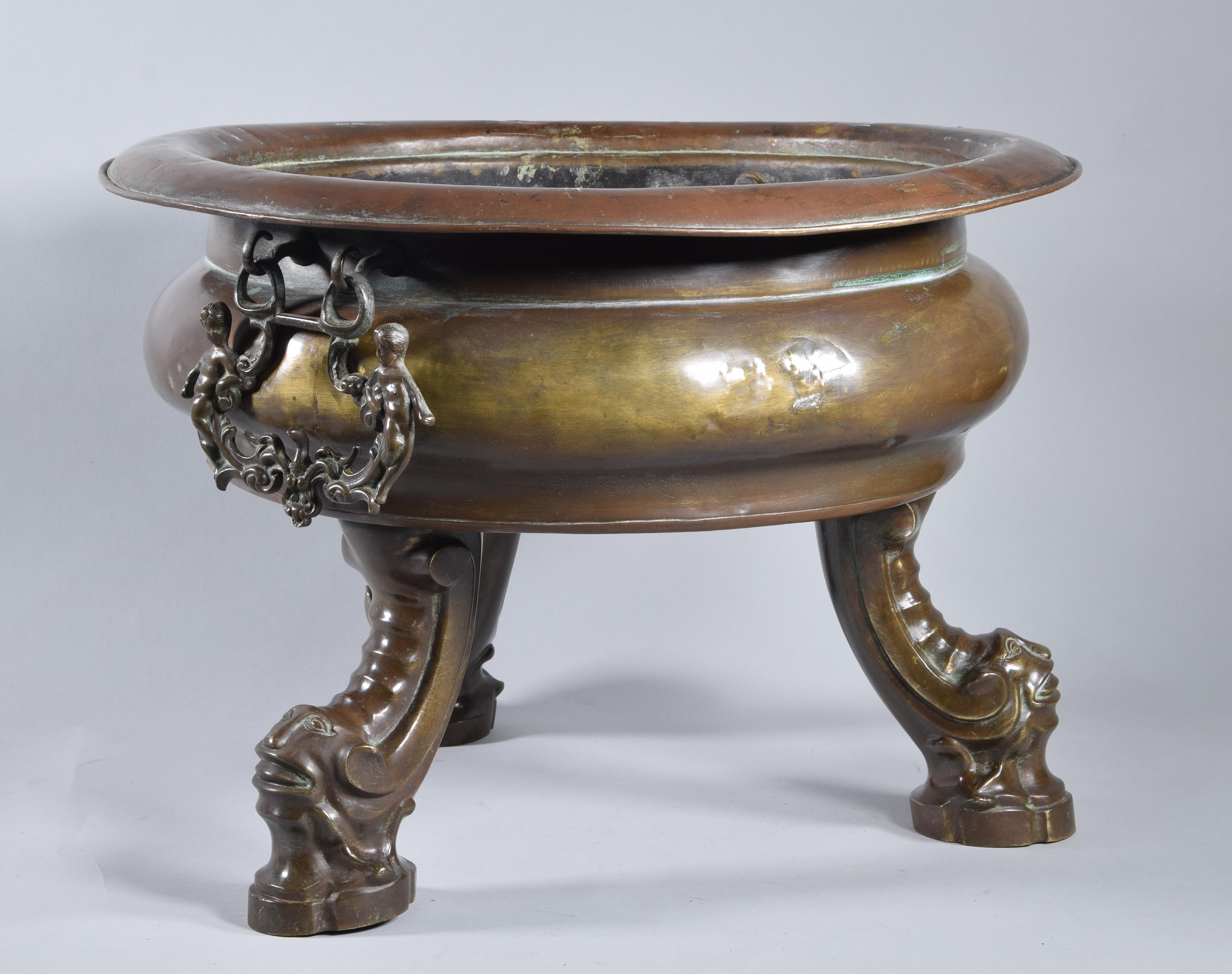 Barocke spanische Bronzelampe auf drei Beinen in Form einer geschwungenen Schnecke, die von grotesken Masken mit künstlichen Gesichtszügen gekrönt wird. Das Gefäß ist abgeflacht und gestaffelt, mit einem deutlichen Schnitt, der den Hals vom Bauch