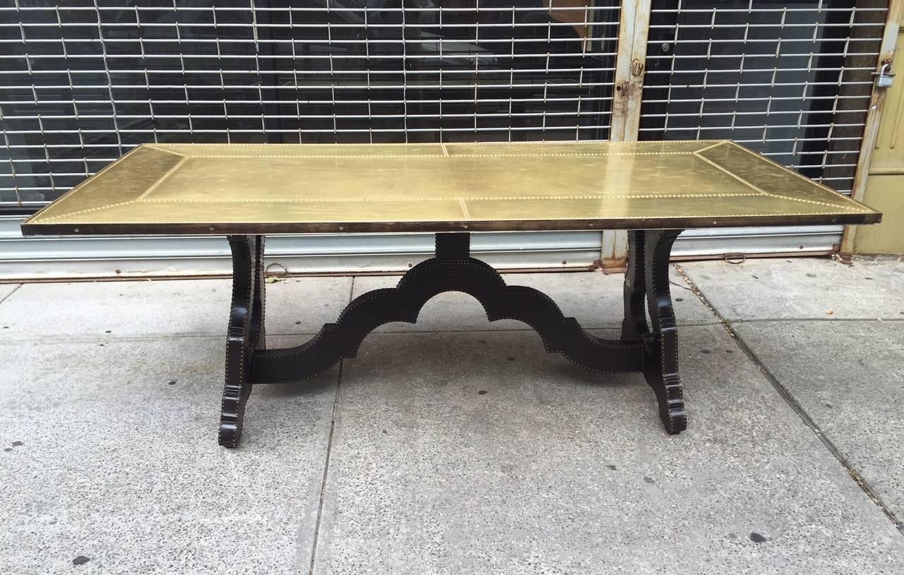 The tabletop is bronze as well as the base. The top is completely etched with a floral pattern. The base could be polished if desired.
The top and base have studded trim. Can also be used as a desk or conference table.