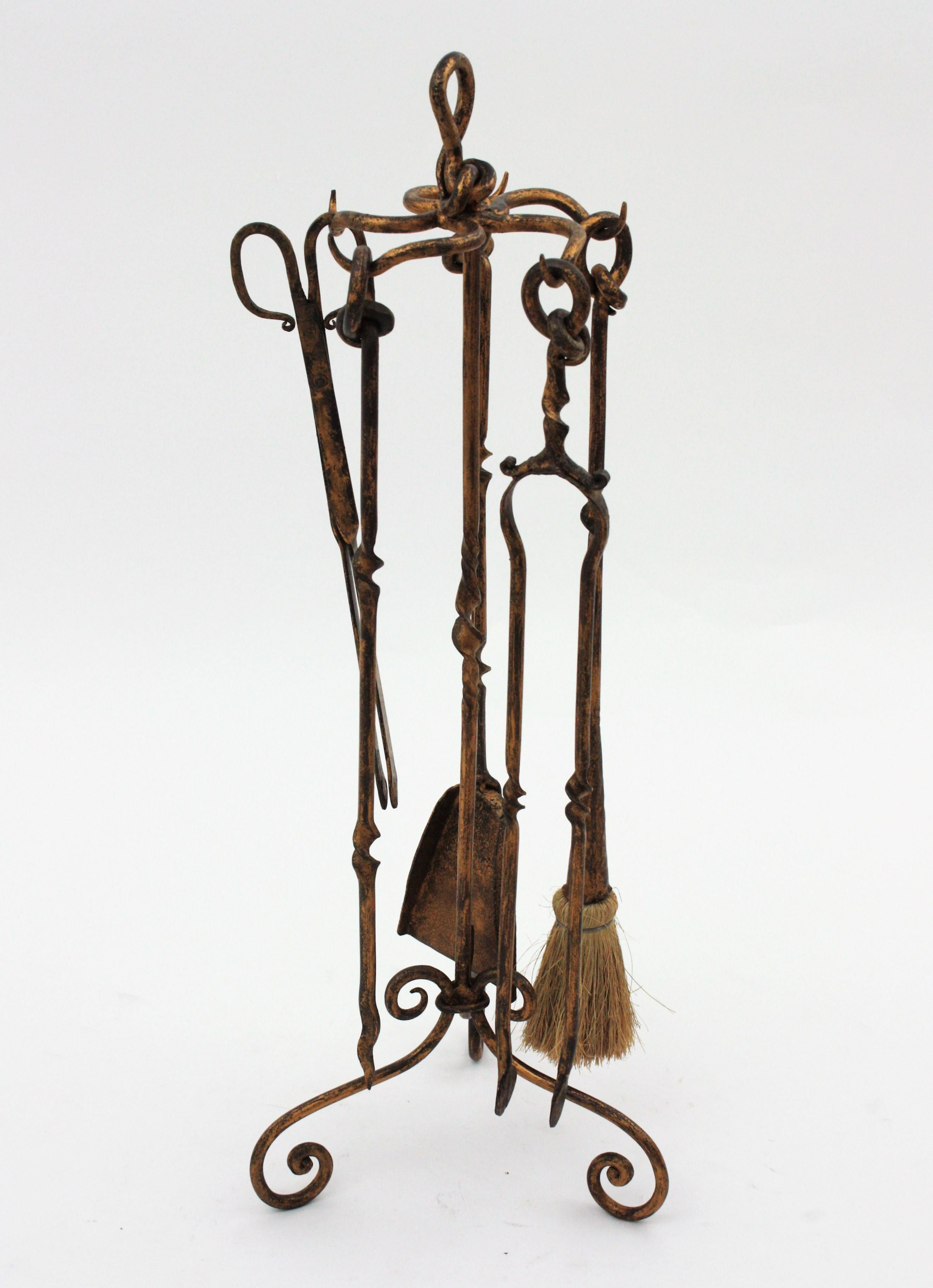 Beautiful Hand forged knot fireplace tool set on stand. Spain, 1950s-1960s
The set includes five hand forged iron tools : a shovel, a log poker, broom, and two tongs. The rack stands up on a tripod base with scrolled ended feet and a knot detail on
