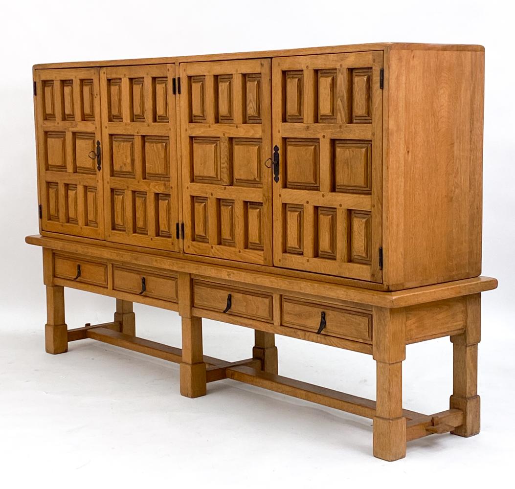 This stunning large case piece has been crafted in solid oak, an eye catching example of the Spanish Brutalist style. This sideboard cabinet has carved decoration on the door panels, with geometrically arranged squares that are slightly recessed