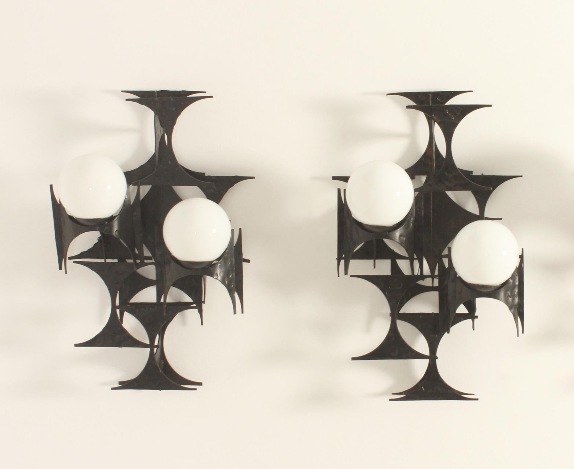 Spanish brutalist sconces with two globes from 1960's. Black lacquered forged iron structure with two opal glass globes.
Three pieces available.
