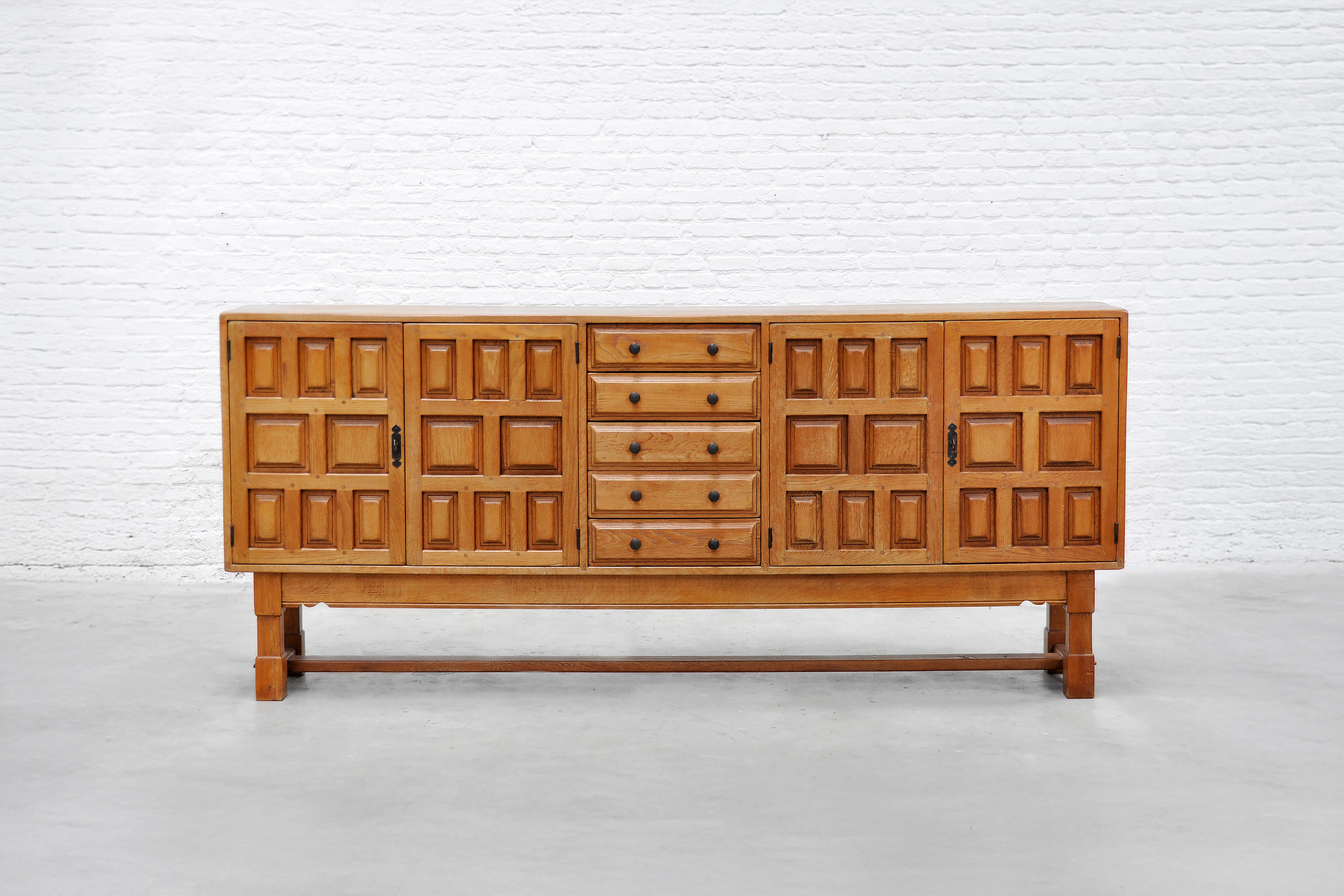 Hand‑made in Spain in the early 1940s, this solid oak sideboard showcases the bold geometry and honest materials that define brutalist design. Four sculpted doors display an irregular, sculptural relief that catches the light and lends the cabinet a