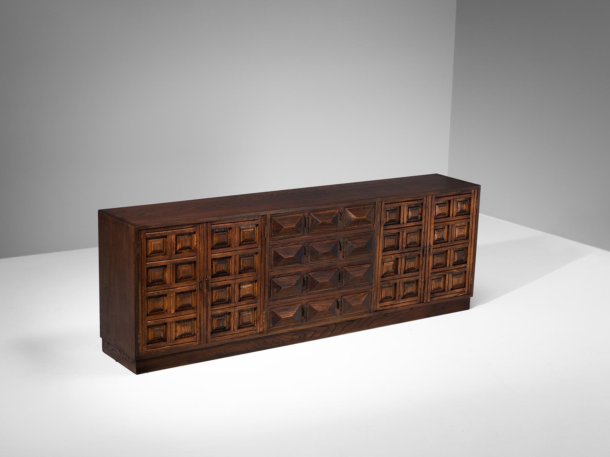 Sideboard, stained ash, iron, Spain, 1970s

This cabinet originates from Spain and shows the decorative characteristics of the 16th century Castilian furniture design. The carved geometric shapes on the door panels immediately catch the eye and