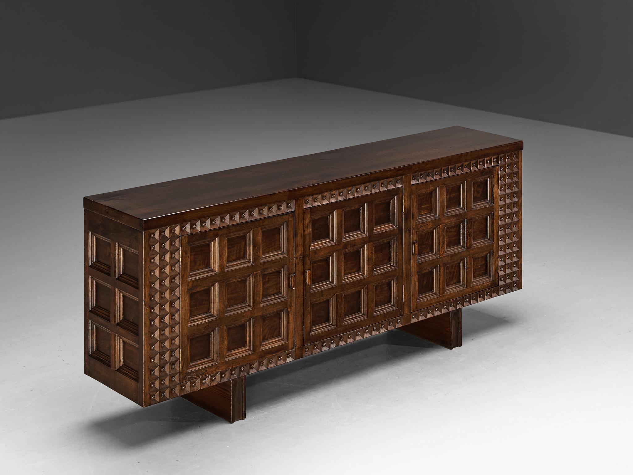 Credenza, field maple, Spain, 1960s 

This large cabinet originates from Spain and stylistically refers to the late 19th century Revival period. The embossed front is characterized by relief carvings with clearly defined squares. Its decorative