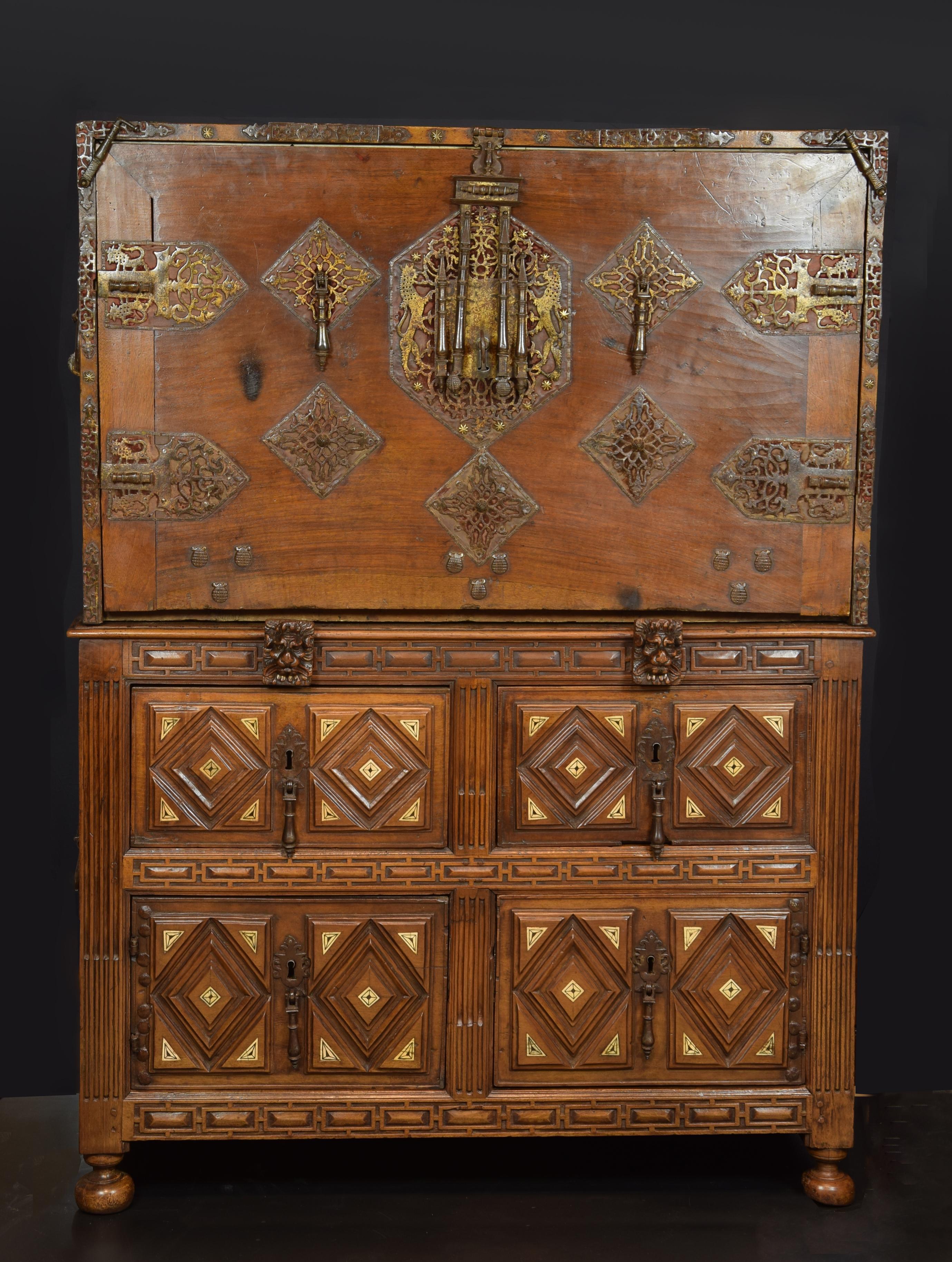 The rectangular locker rests on four round legs, and has four drawers decorated with diamonds that lock and fittings and shield shown horseshoe. Desk, hinged front cover has metal hooks (to attach the table without lock) and numerous decorative