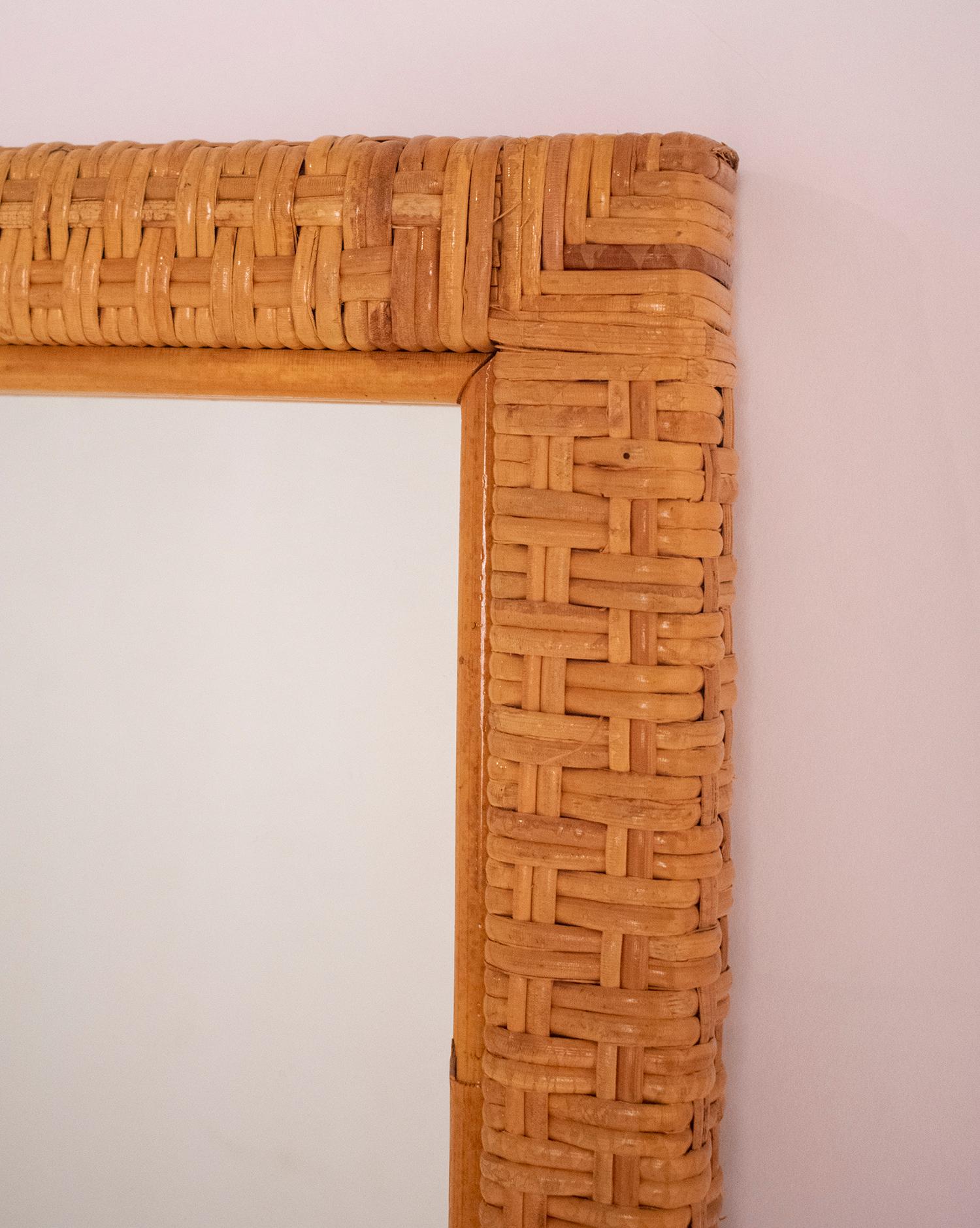 Nice midcentury rectangular  cane and woven wicker mirror. This fantastic piece was designed in Spain during the 1970s.
It is to be placed vertically, but the mirror could also be placed horizontally.
The wicker weave is very beautiful and they are