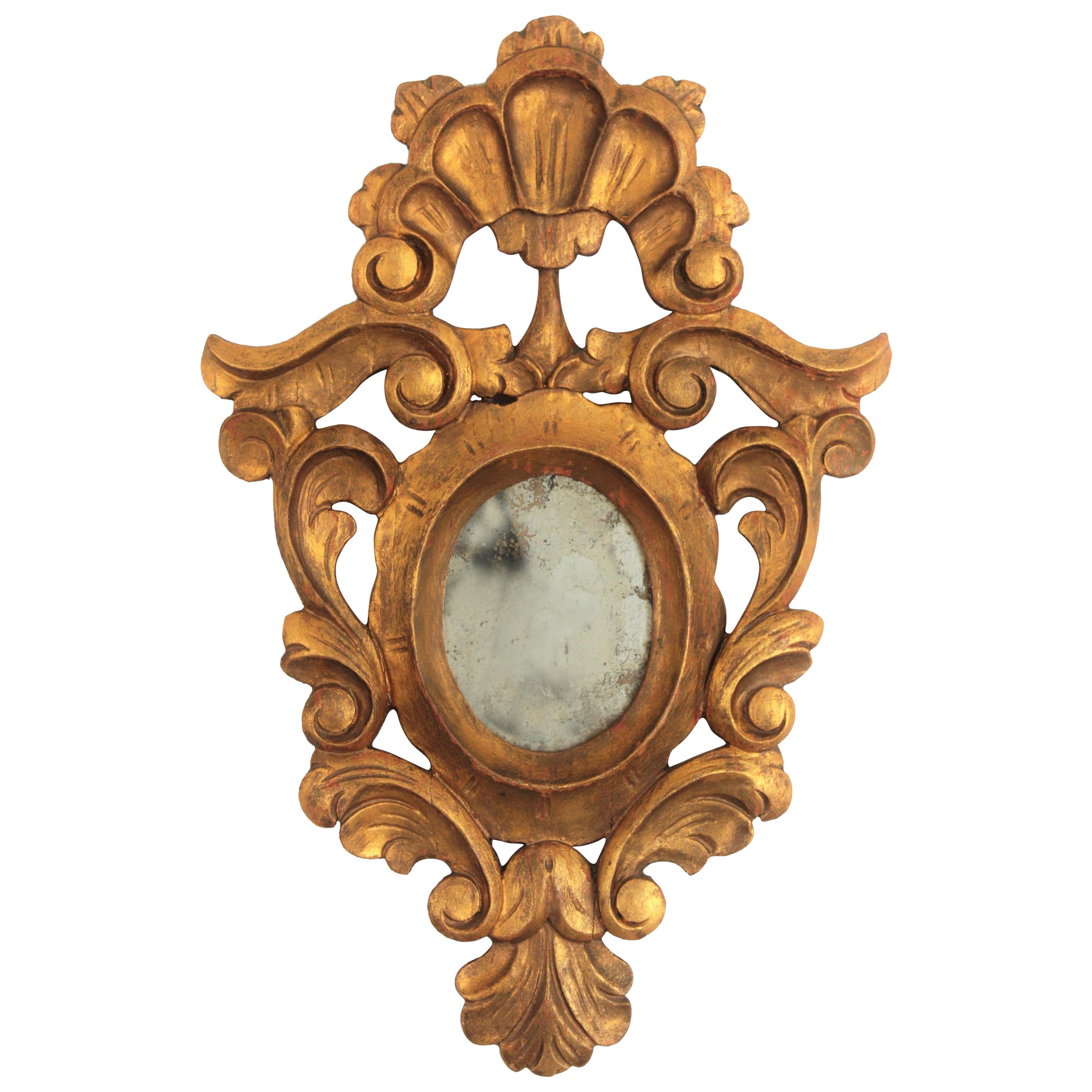 Rococo mirror, carved giltwood, Spain, 1920s.
Lovely Rococo style small mirror with a carved giltwood frame surrounding an oval shaped glass. Itf has a beautiful crest adorning the top and naturalistic decorations at the frame. This piece it is