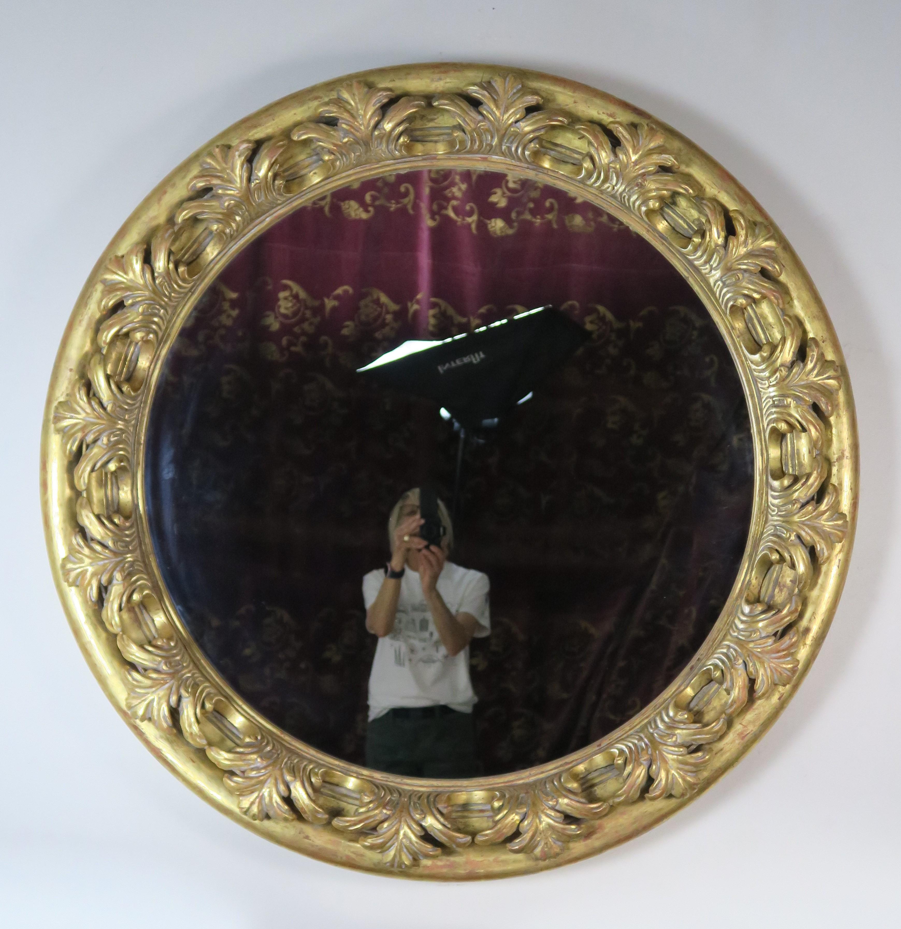 Spanish carved 22-karat giltwood round shaped mirror with carved acanthus leaf pattern throughout the mirror.