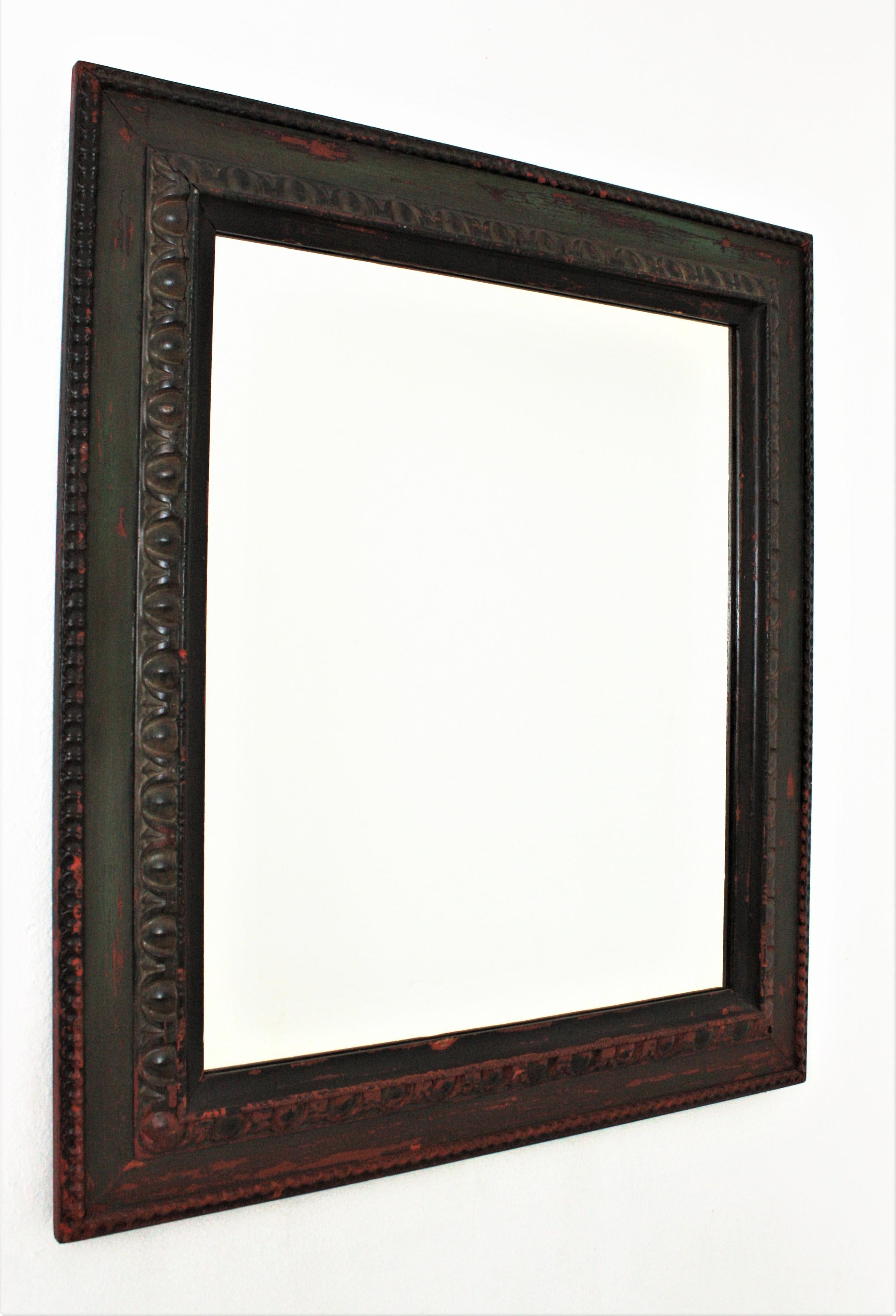 Spanish Baroque style carved wood green painted rectangular mirror, circa 1920s.
This hand carved wood rectangular frame has beautiful patterns surrounding the glass. It has a nice aged patina in green color with terracotta accents.
An excellent