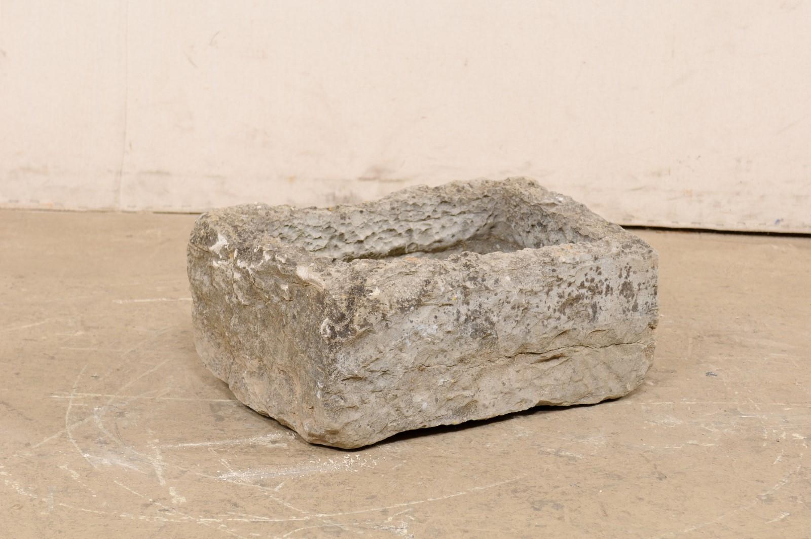 A Spanish carved-stone trough from the early 20th century. This antique garden basin from Spain is rectangular in shape, which has been hand-carved out of a single piece of stone. This piece has a nicely textured surface and patina throughout. In
