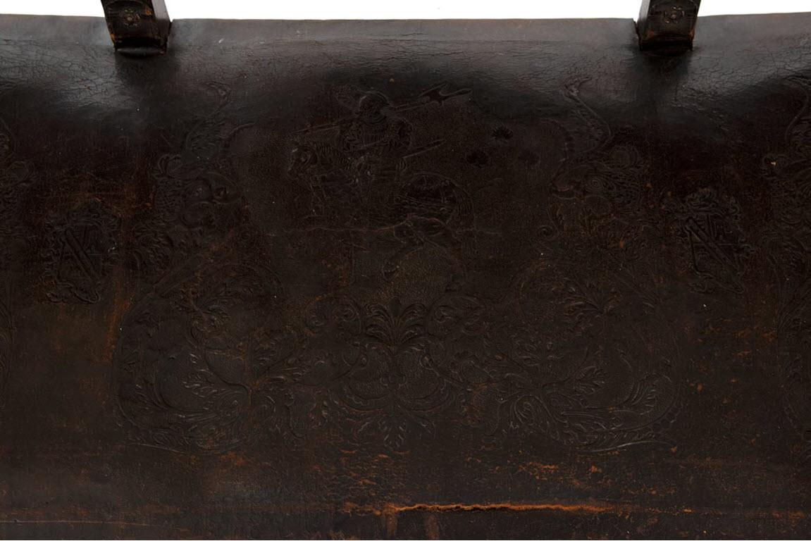A large carved walnut bench with stamped Cordovan leather upholstery.

Measures: 54 x 72 x 27 in.