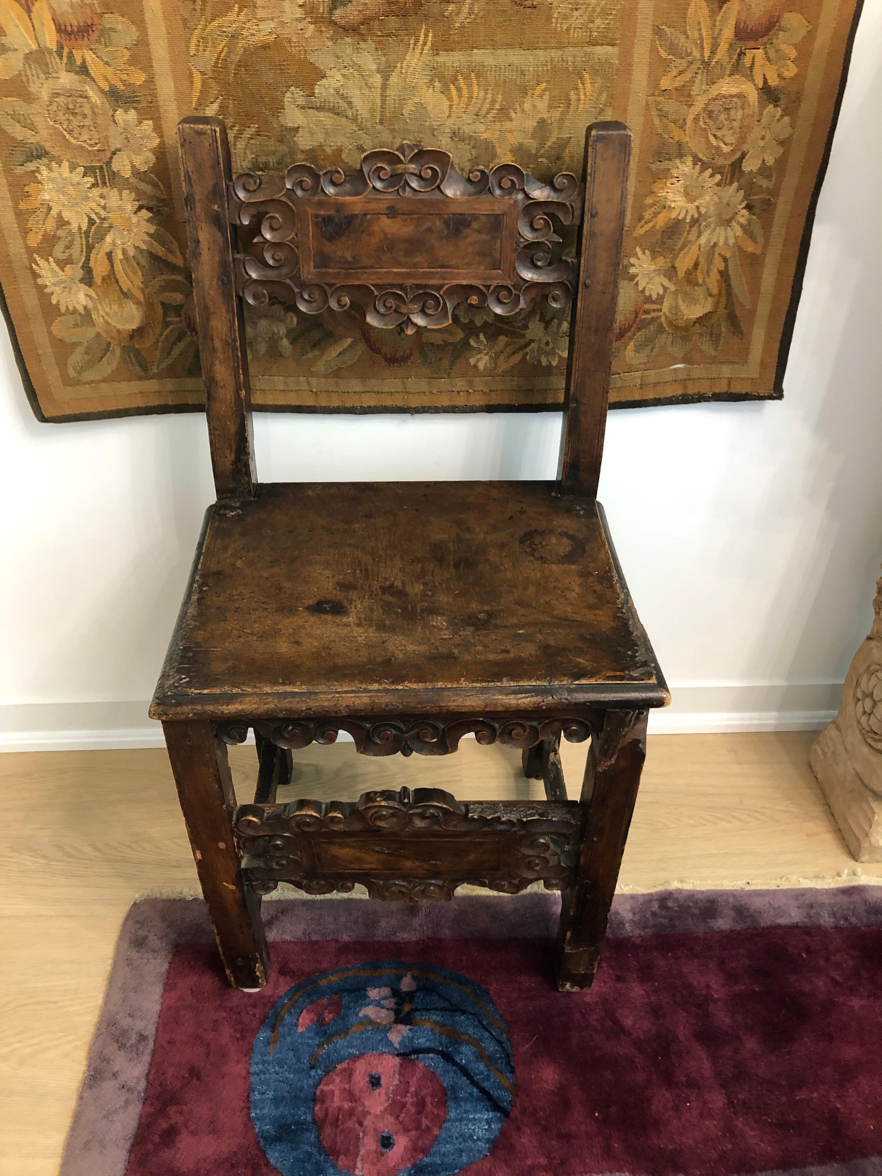 This is a wonderful and very old Spanish chair, made of carved walnut. Possibly 17th century.
The shape is typical of 17th century Spanish chairs. The back and front rail each sporting a cartouche design with scrolled borders.
Beautiful patina. The