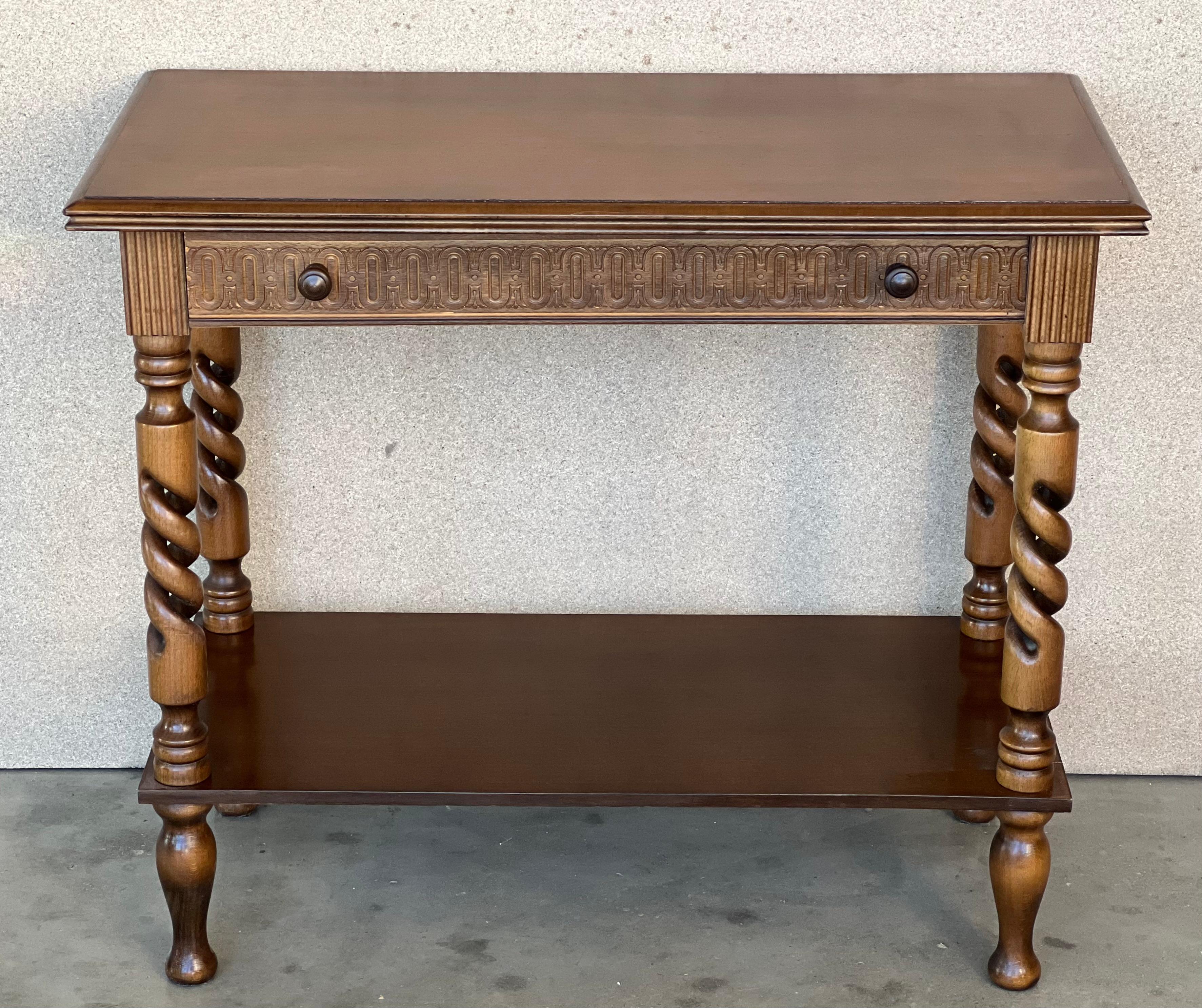 A 20th century walnut console table with a slab top above a frieze with one drawer with front decorated with carved floral motifs and incised with additional decoration and a double pull in drawer. The table is supported on a hand carved base with
