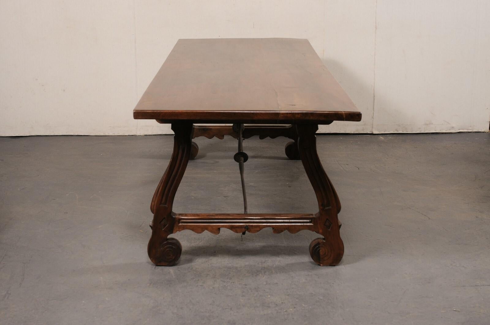 Tavolo con gambe a cavalletto in legno di noce intagliato in Spagna, con barella in ferro forgiato, lungo più di 8 piedi in vendita 1