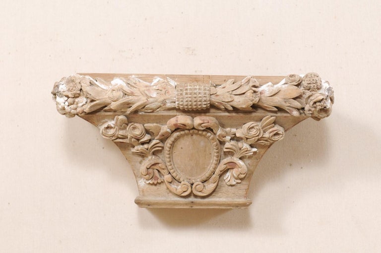 A Spanish carved-wood capital wall bracket from the 19th century. This antique architectural wall ornament from Spain features a rectangular-shaped top, which rests upon a trapezoidal shaped body below, which tapers down towards it's flattened
