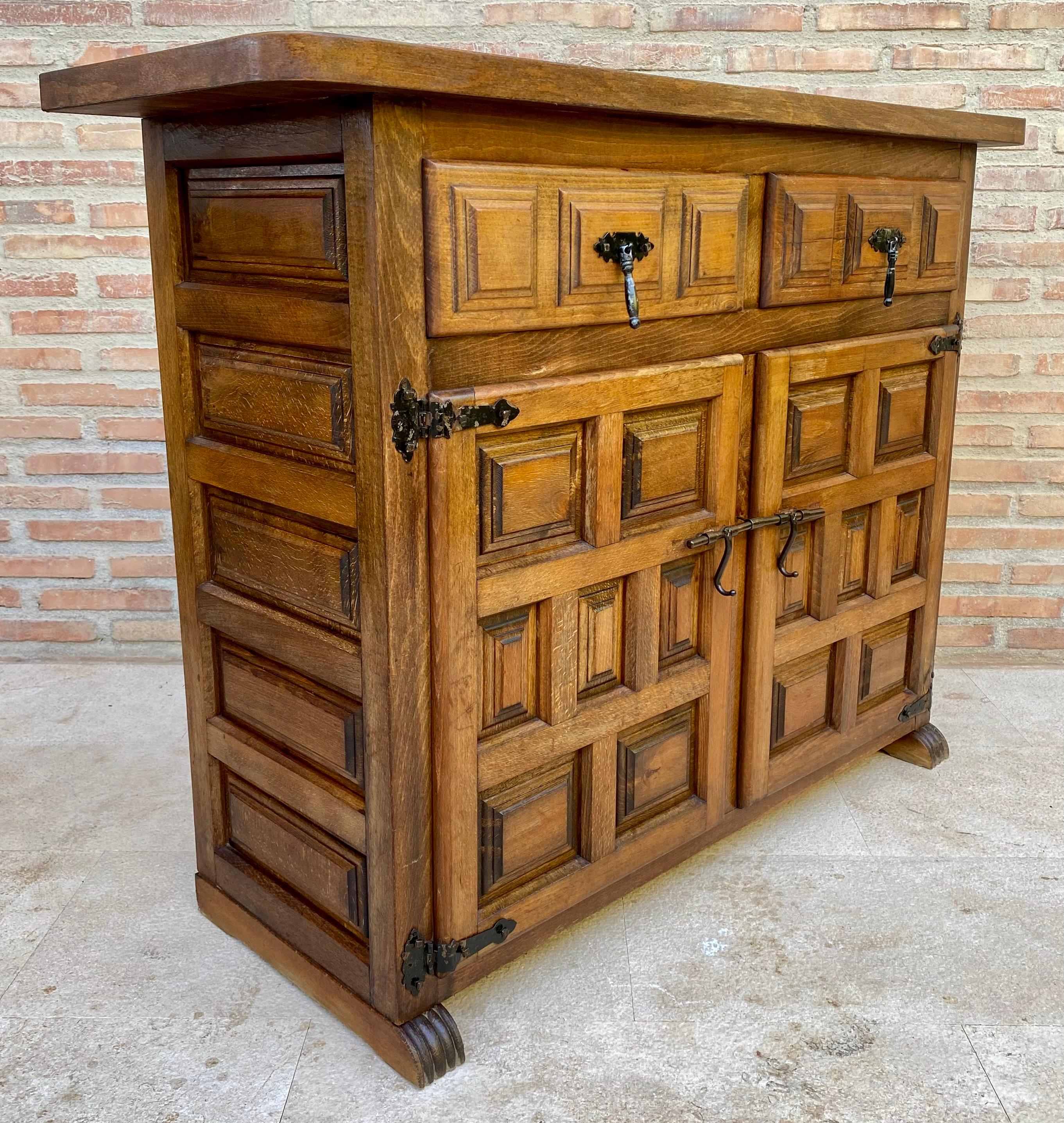20th century Catalan Spanish carved walnut chest of drawers, highboy or console Country Provincial Chiffoniere was fashioned from solid walnut and features two drawers and two doors carved with charming detail and fitted with unusually intricate