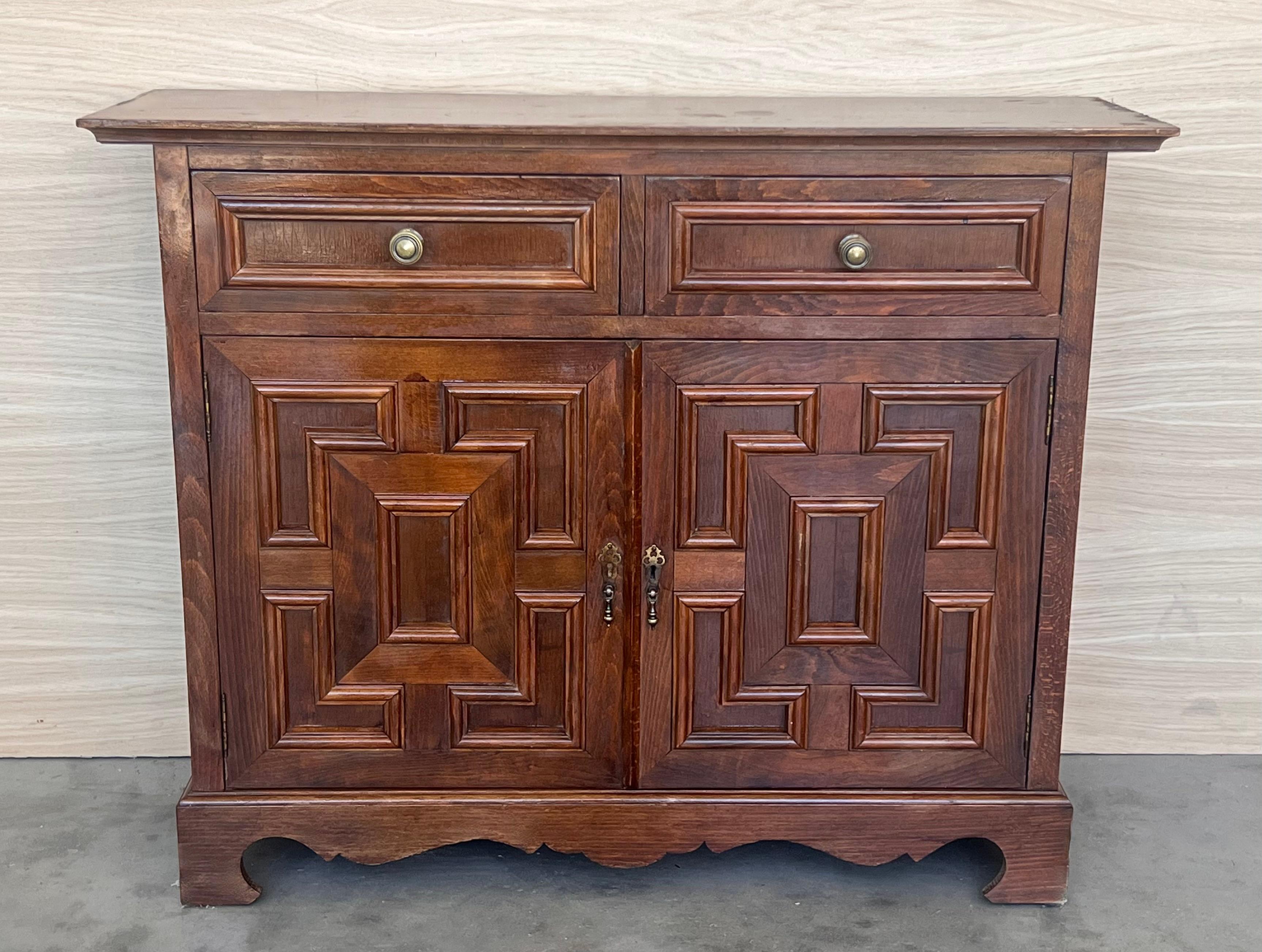 20th century Catalan Spanish carved walnut chest of drawers, highboy or console Country Provincial Chiffoniere was fashioned from solid walnut and features two drawers and two doors carved with charming detail and fitted with unusually intricate