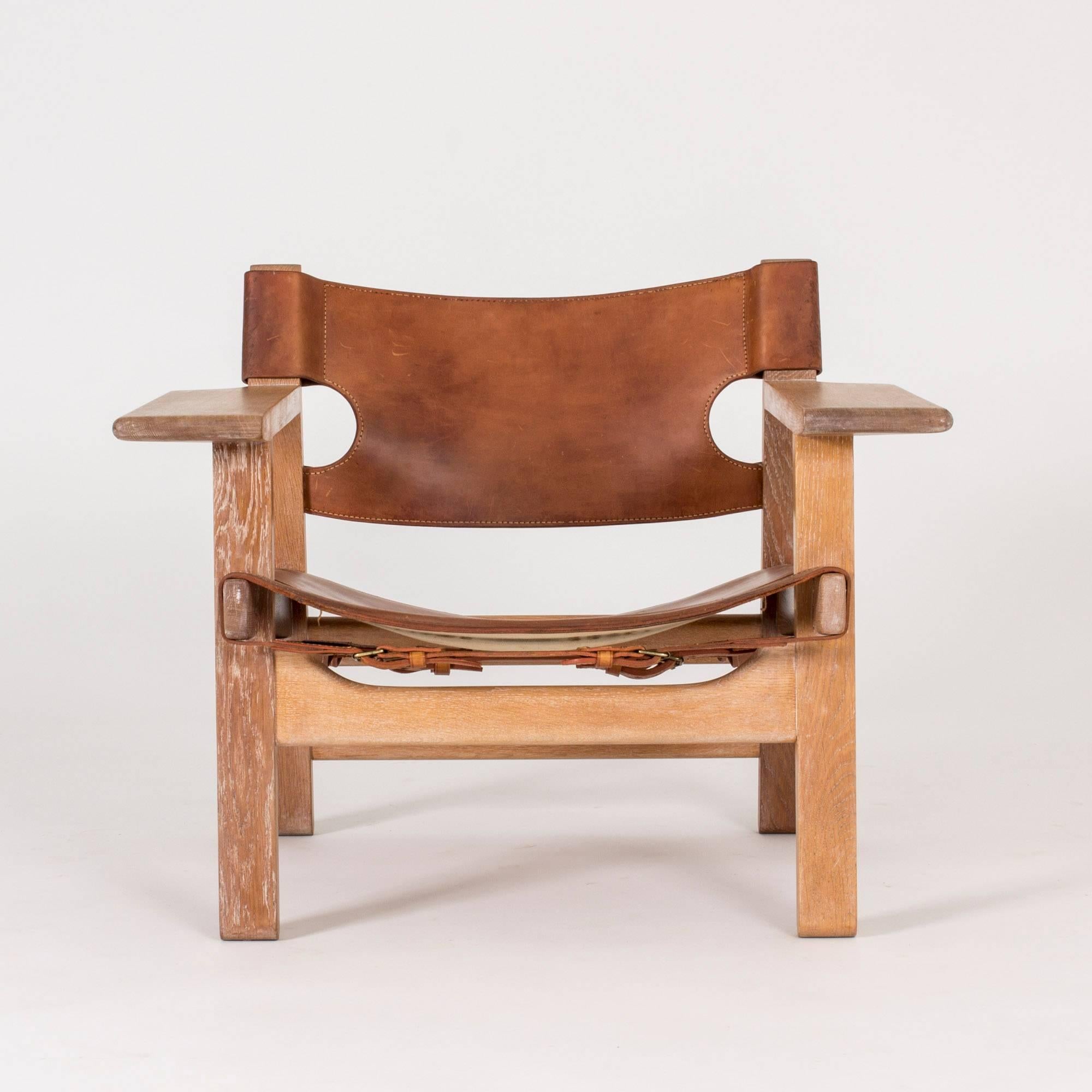 Iconic oak and cognac leather “Spanish Chair” lounge chair by Børge Mogensen. Mogensen got his inspiration for this design from a trip to Spain in 1958, where he came across a type of traditional chair which he then interpreted in a modernist way.