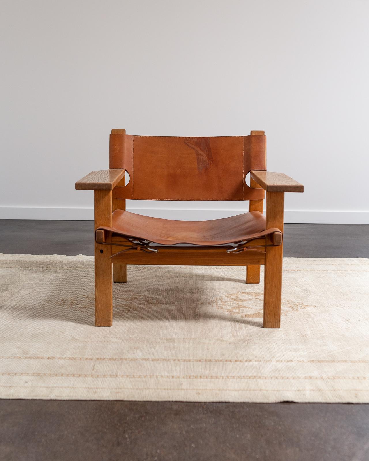 The Spanish Chair designed and heavily influenced after Børge Mogensen's travels to Spain in the 1950's, takes inspiration from the traditional Spanish technique of robust leather as part of furniture construction. The leather has been conditioned